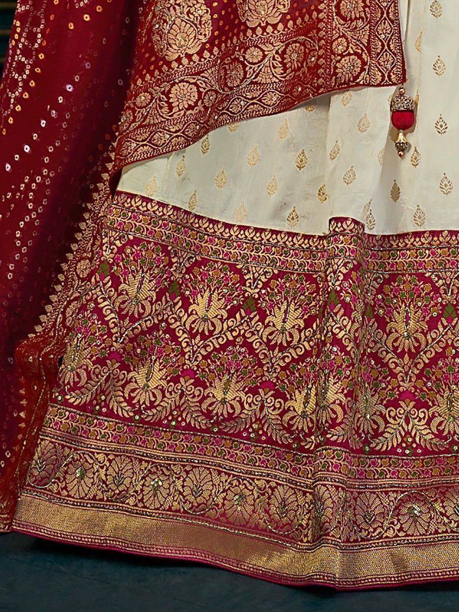 Richly embroidered maroon lehenga with gold floral motifs and contrasting white blouse, perfect for Indian ethnic wear.
