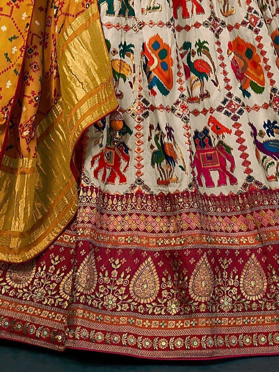 Colorful Indian lehenga with elephant and floral embroidery, gold border, and red dupatta