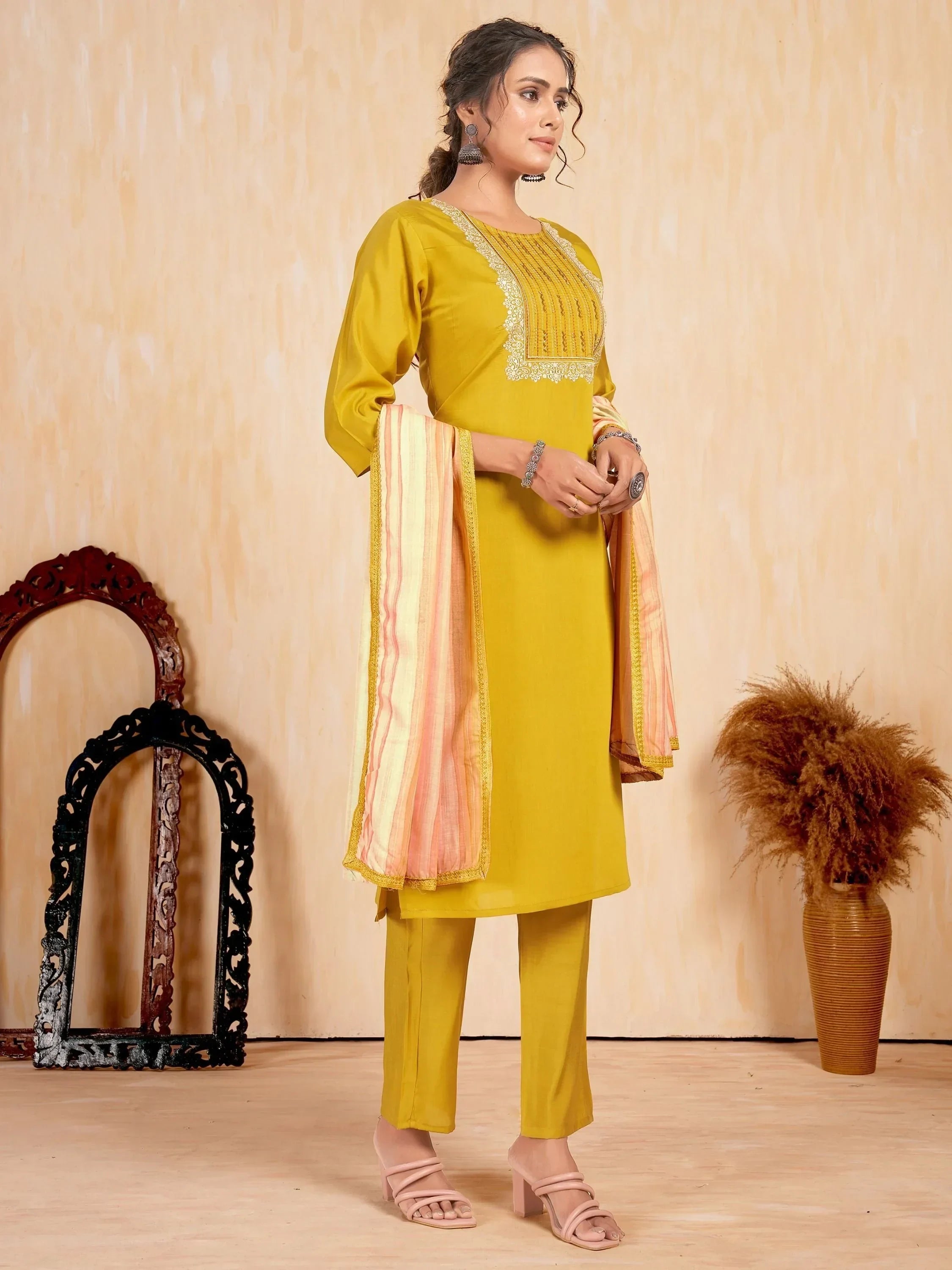 Woman wearing mustard yellow straight cut salwar kameez with striped dupatta and embroidery