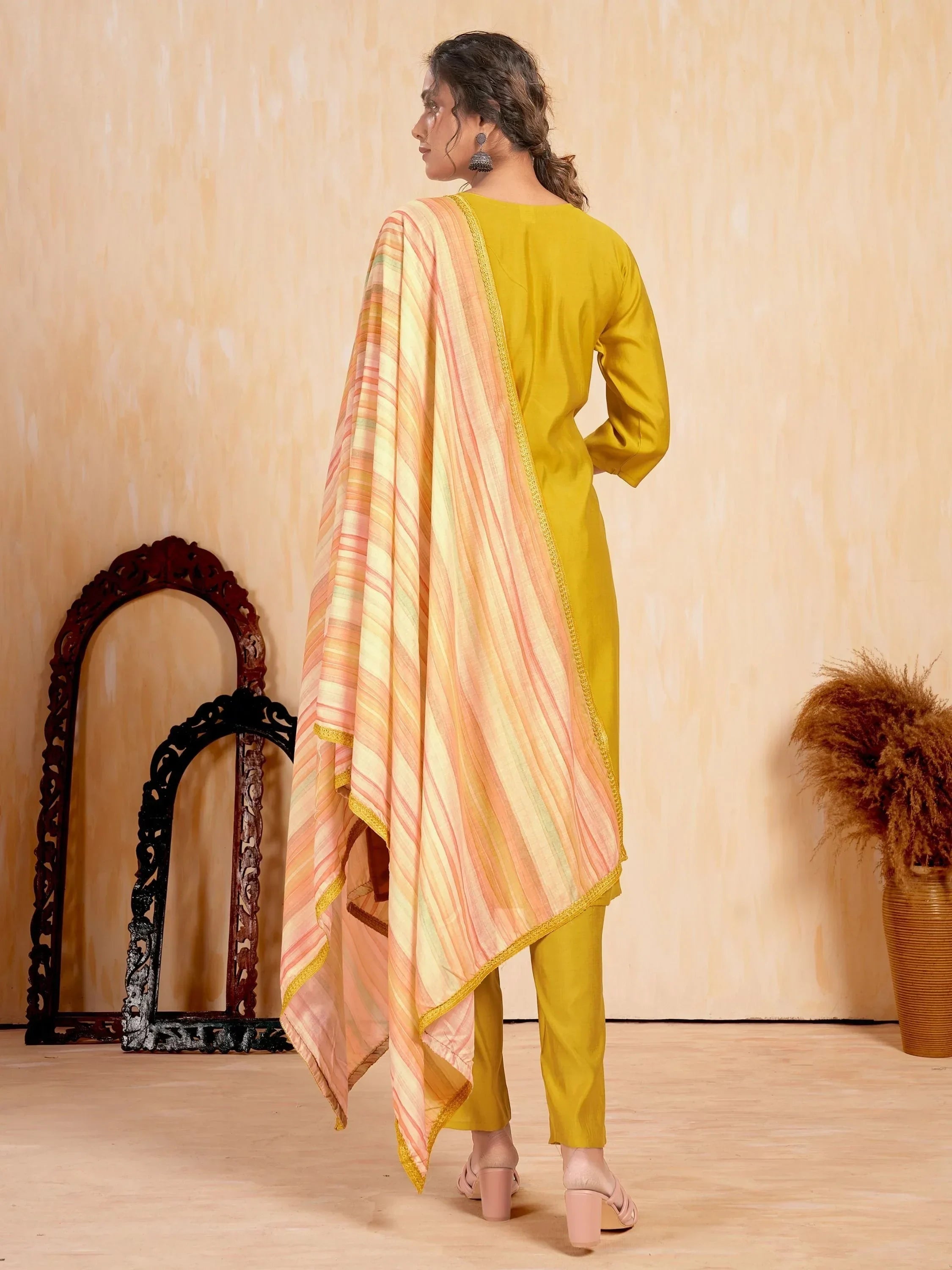 Woman in yellow salwar kameez with striped dupatta, ethnic Indian wear, back view