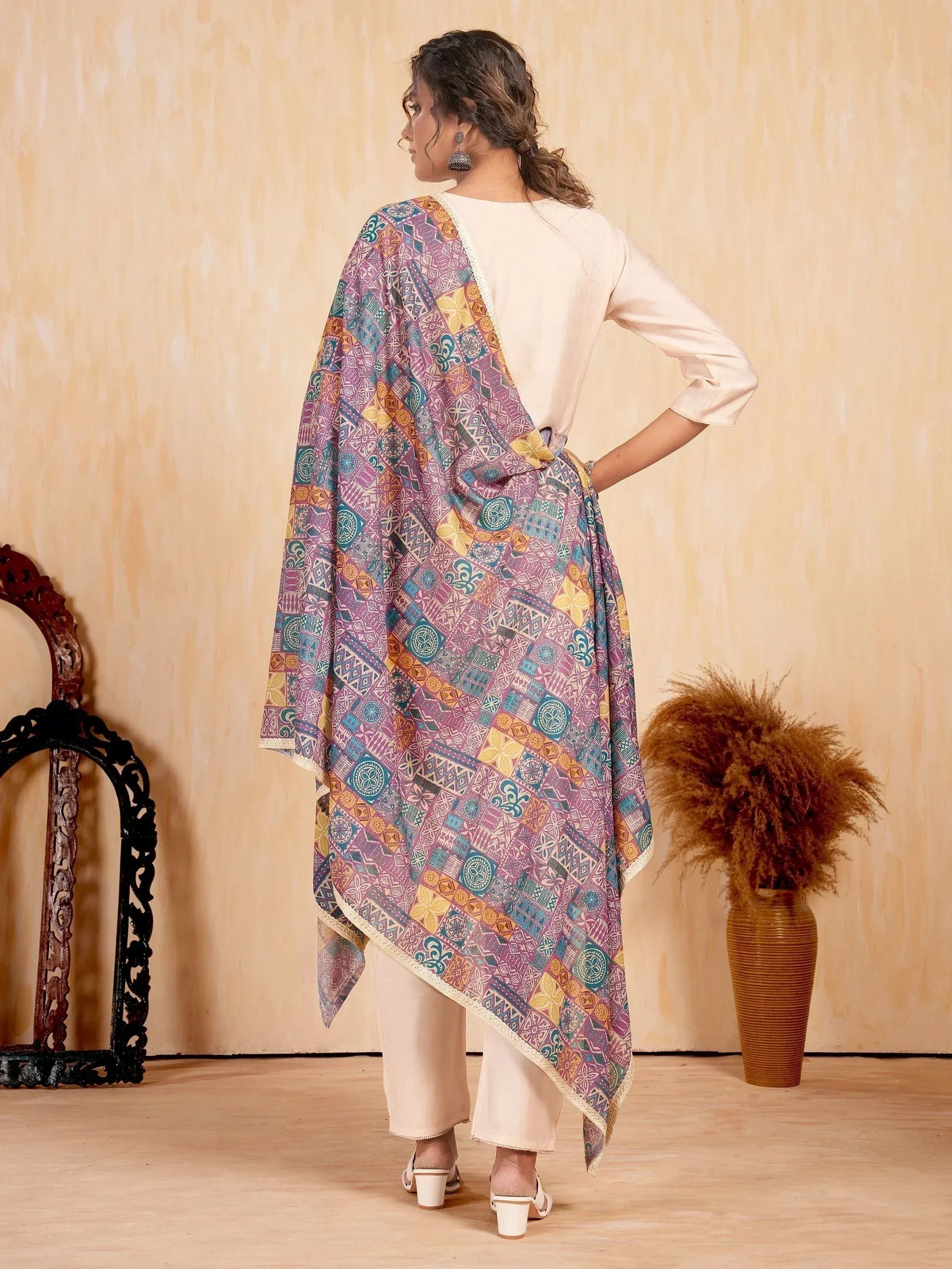 Woman wearing colorful printed dupatta with ethnic patterns, paired with cream kurta and pants for traditional Indian wear