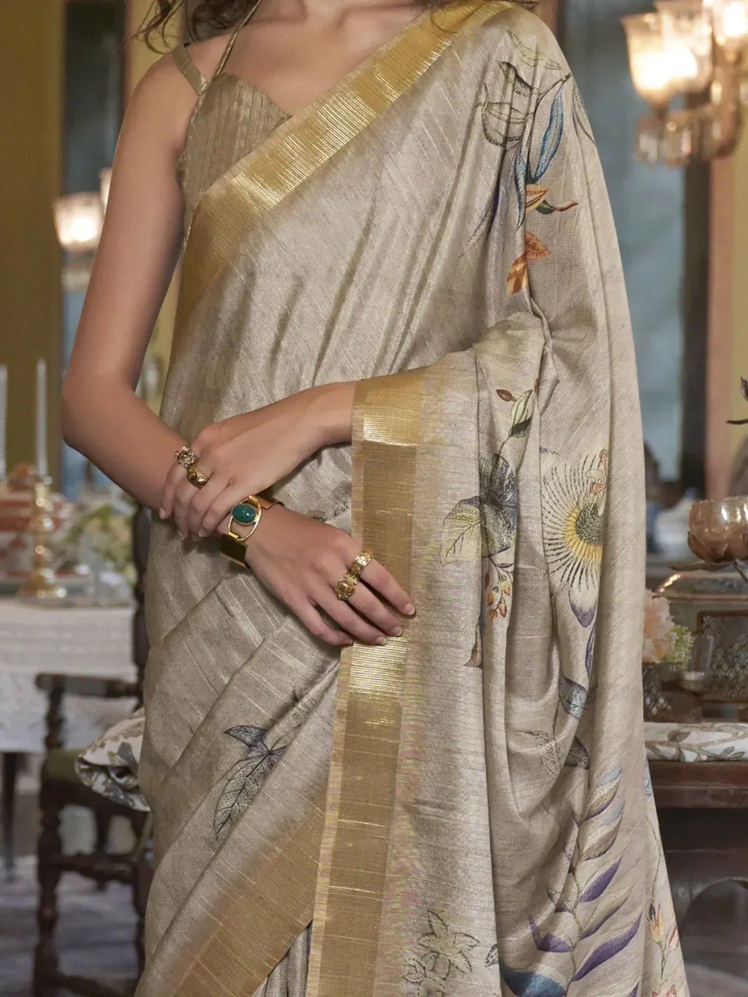 Beige floral printed saree with gold border, paired with spaghetti strap blouse, ideal for Indian ethnic wear.