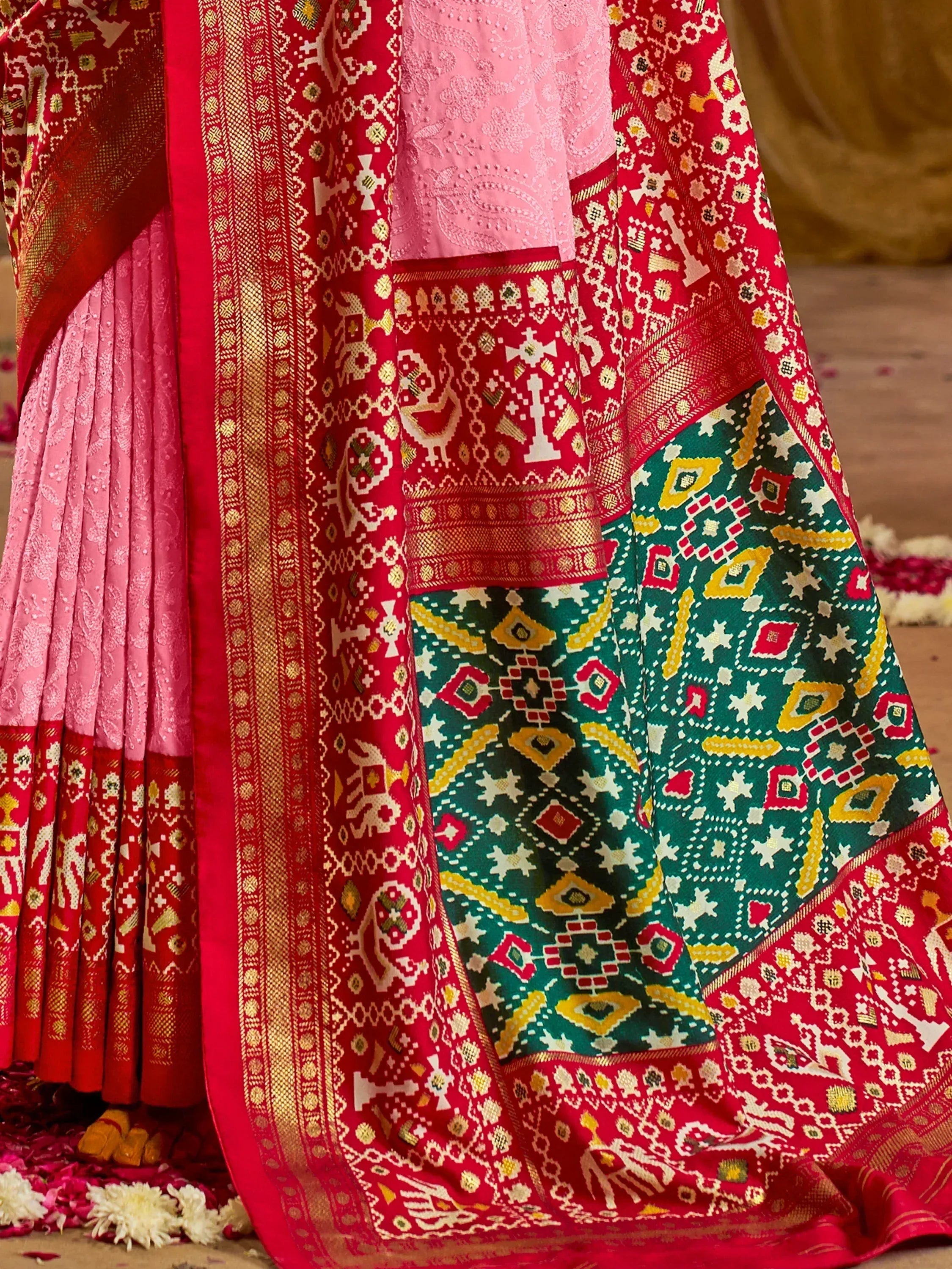 Pink and red embroidered lehenga choli with intricate geometric patterns and gold detailing