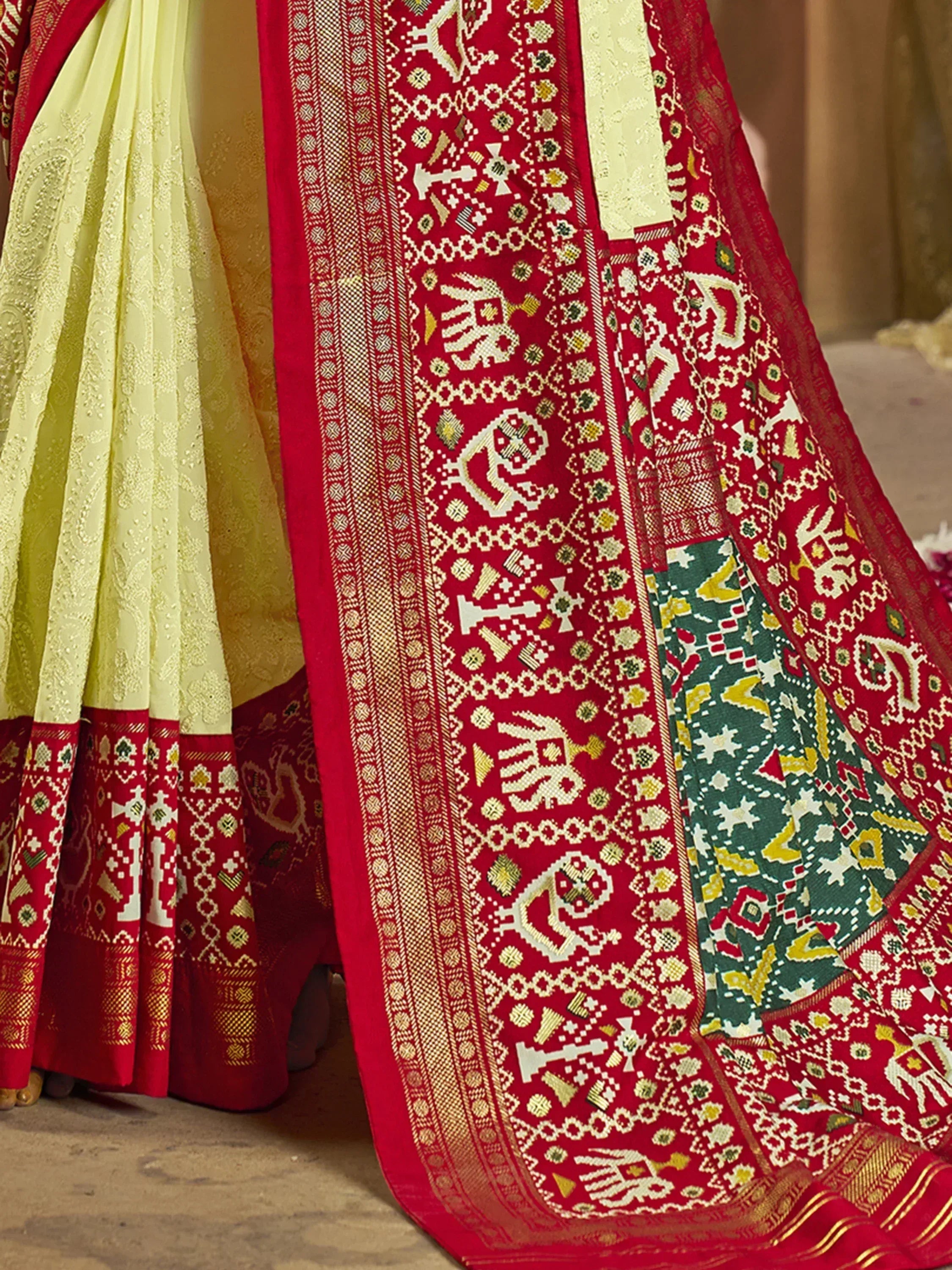 Red and cream ethnic saree with intricate elephant and geometric patterns, perfect for Indian celebrations