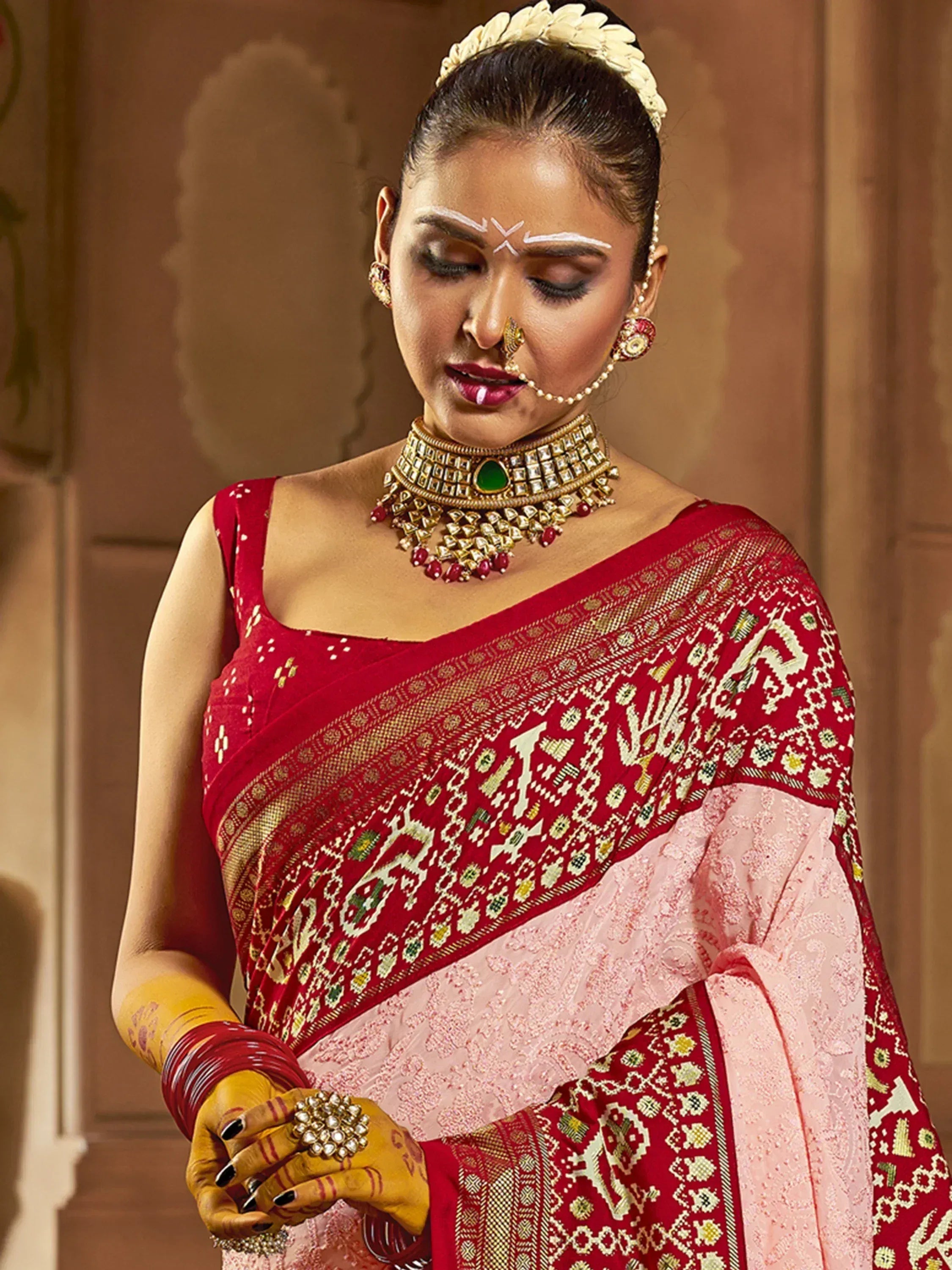 Red and pink embroidered saree with gold jewelry, traditional Indian ethnic wear for weddings