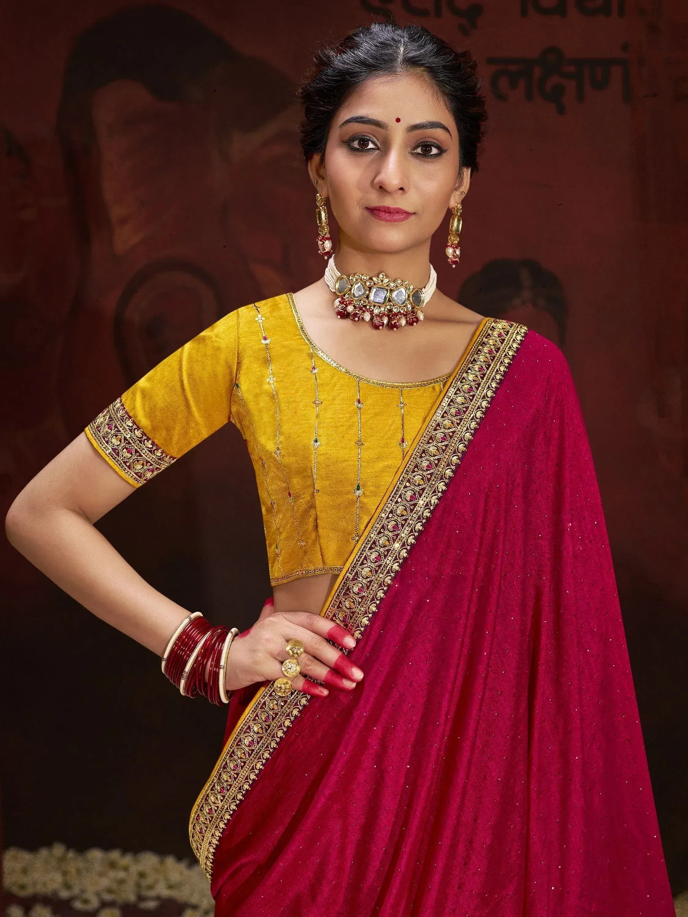 Woman in maroon saree with gold border and yellow blouse, traditional Indian ethnic wear
