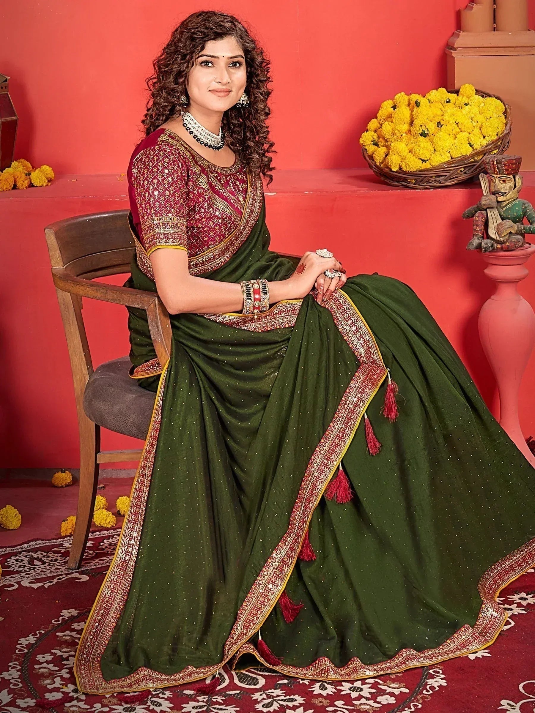 Woman in green and maroon embroidered saree with tassels, traditional Indian ethnic wear