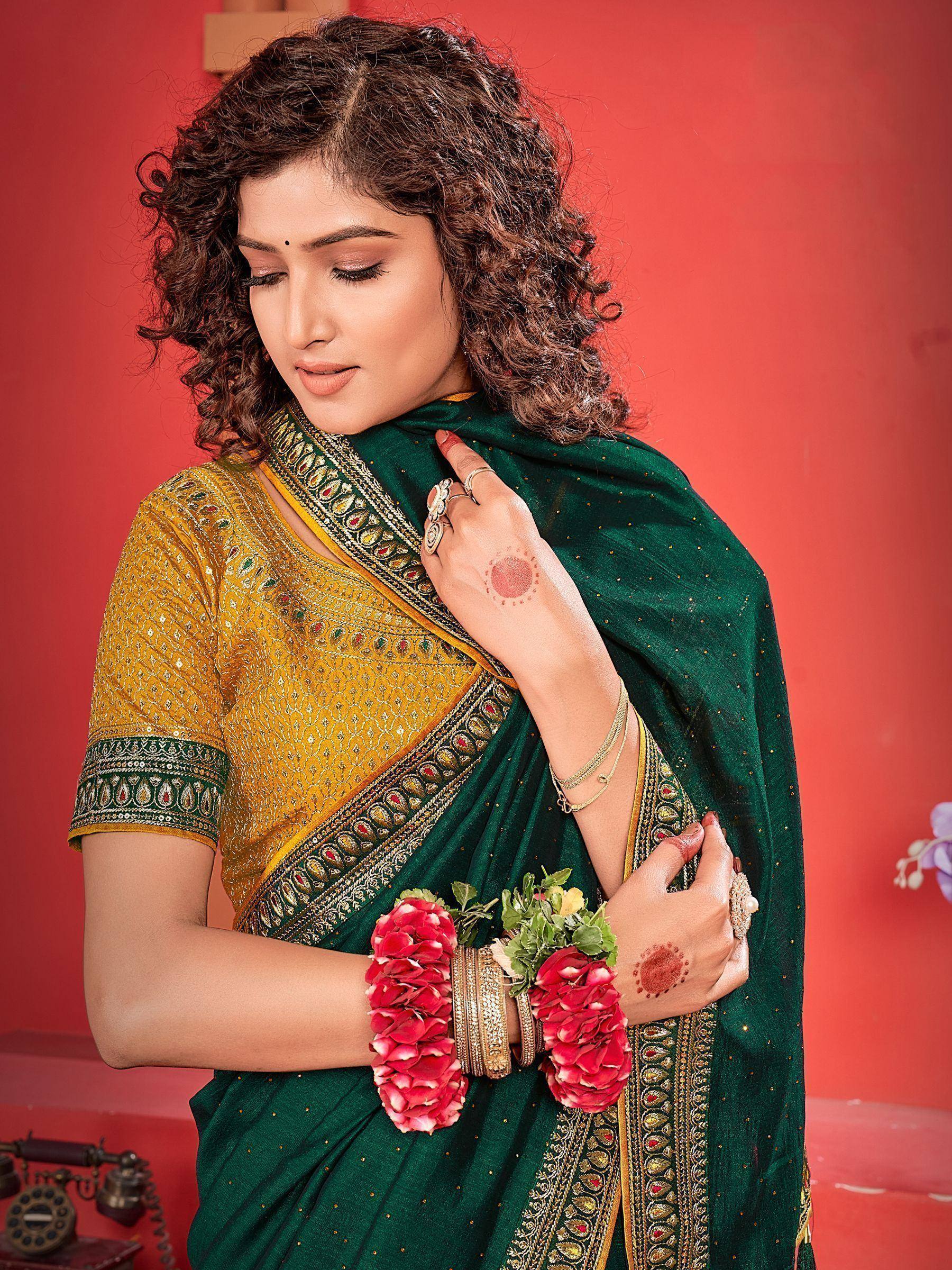 Woman in green and gold embroidered saree with floral wristbands, traditional Indian ethnic wear