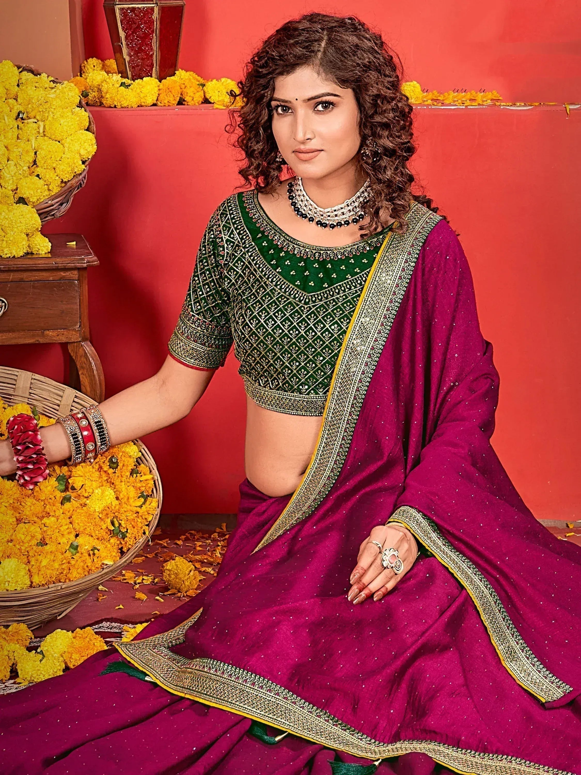 Woman in purple saree with green embroidered blouse, festive marigold flowers, traditional Indian ethnic wear