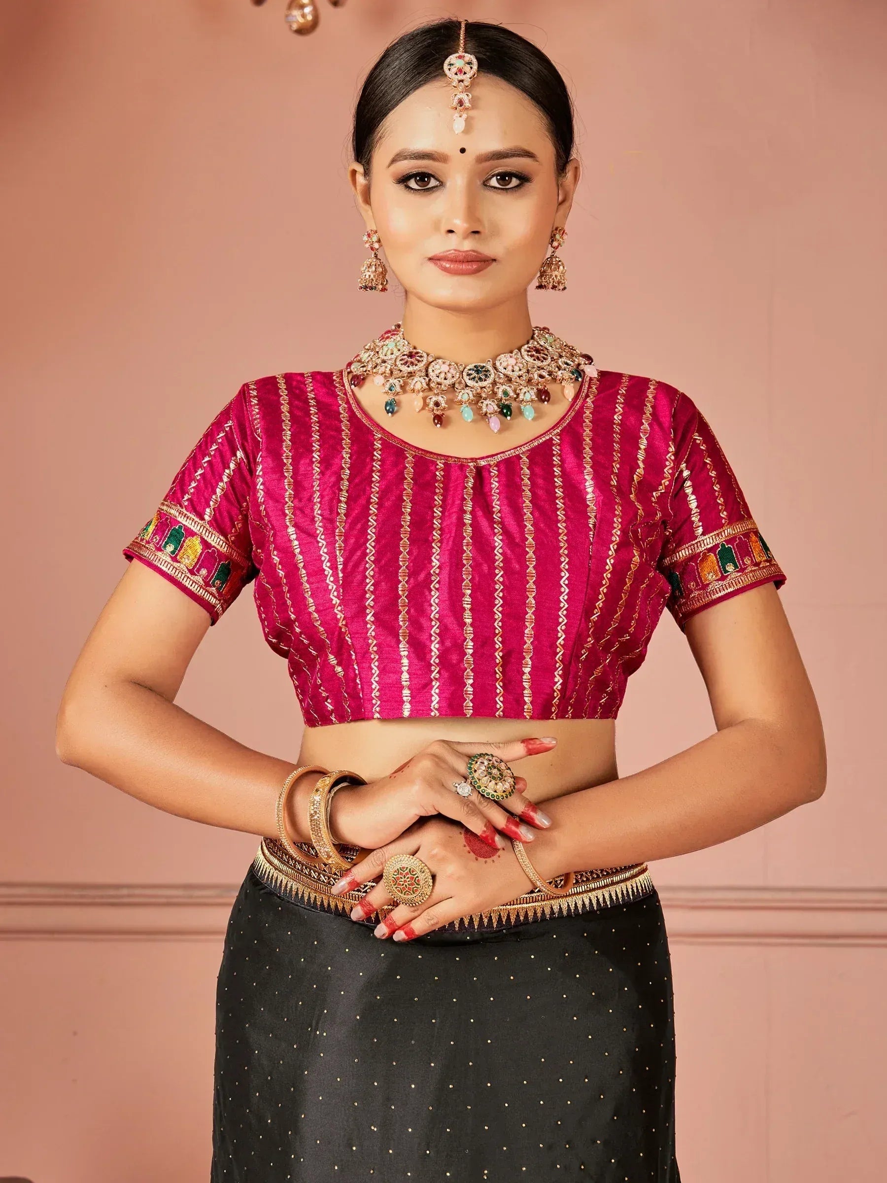 Pink embroidered crop top with black skirt, traditional Indian ethnic wear, perfect for festive occasions.