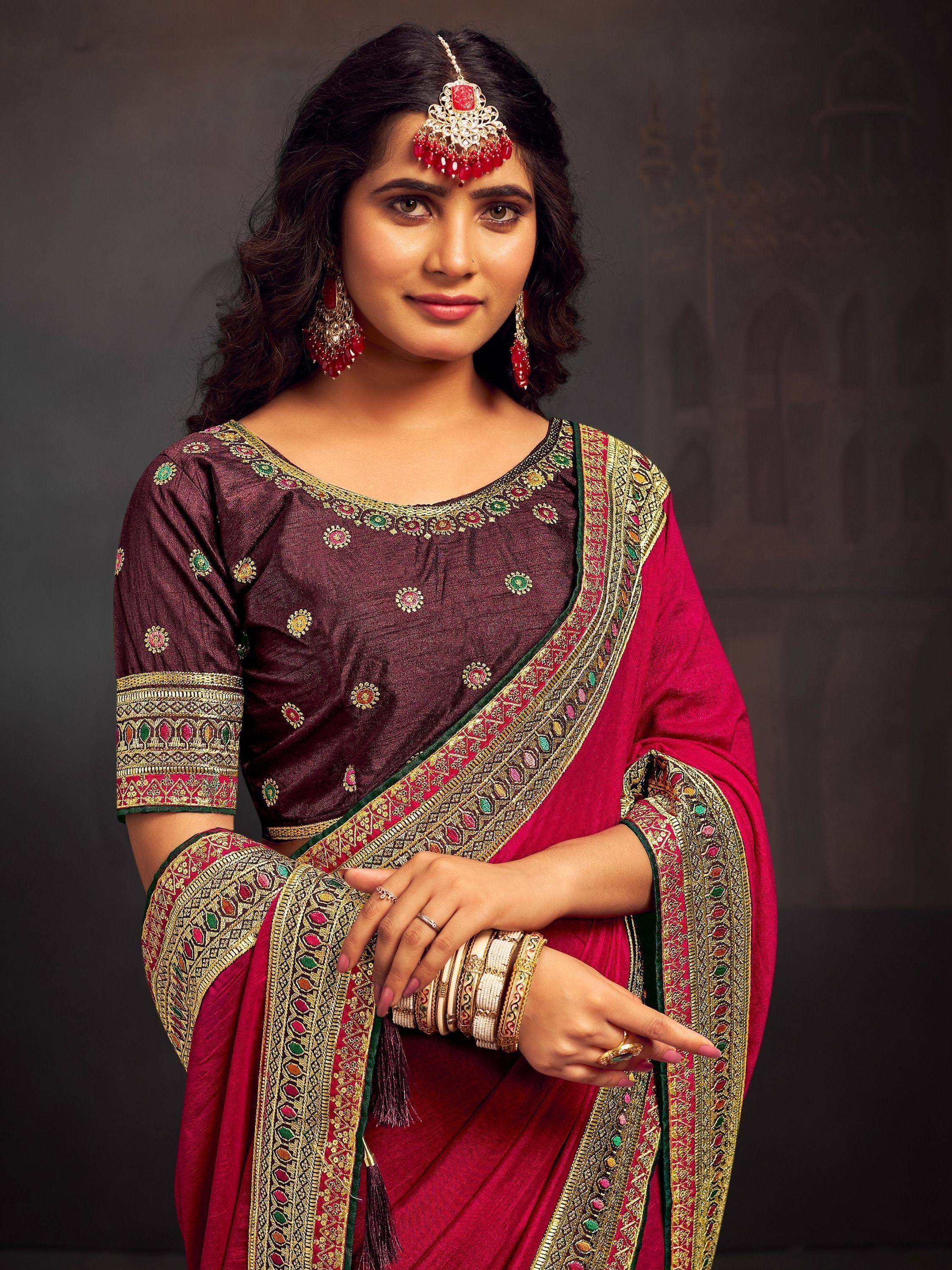 Woman in maroon and pink embroidered saree with gold detailing, traditional Indian ethnic wear