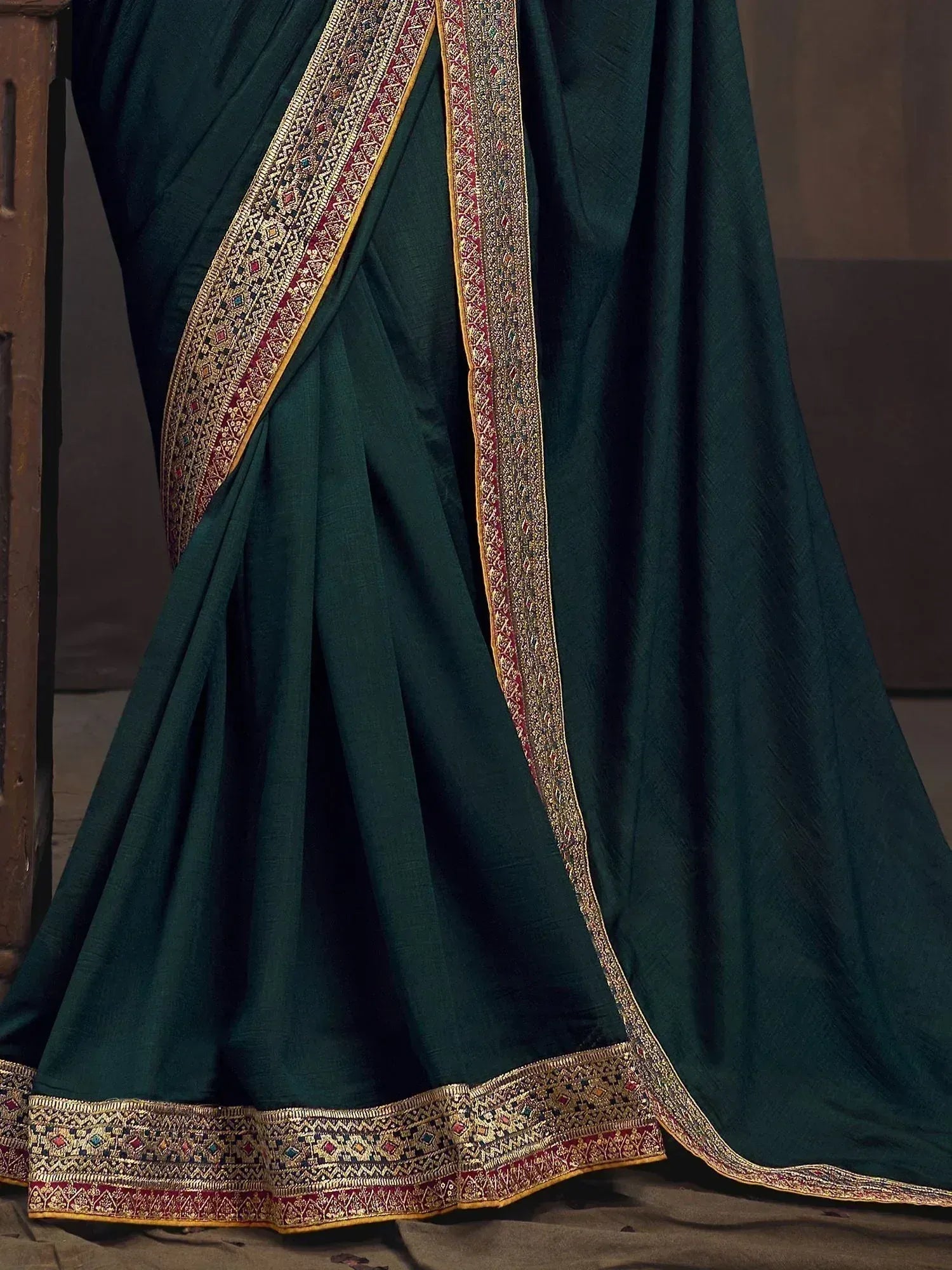 Emerald green saree with intricate gold and red border, traditional Indian ethnic wear