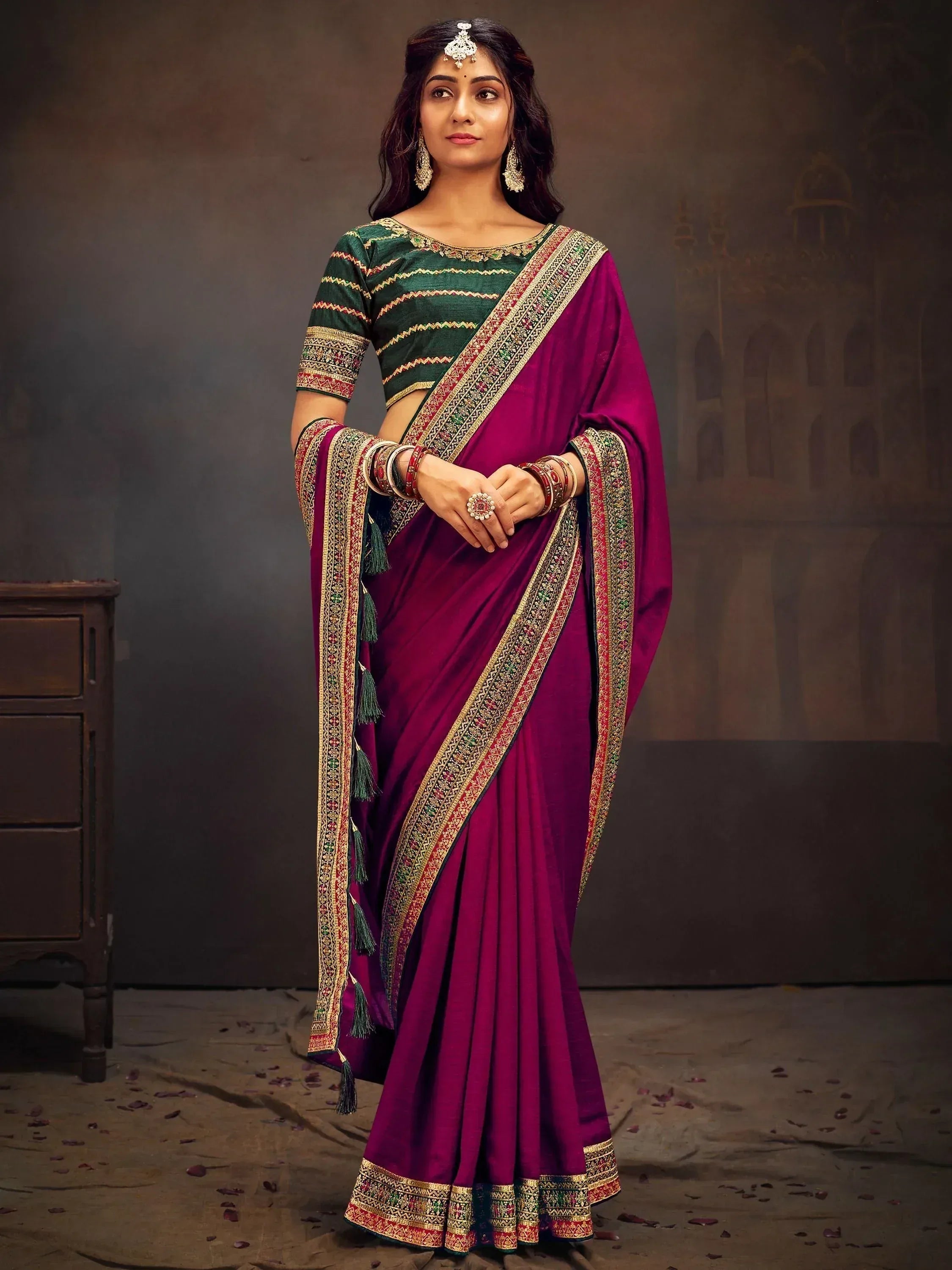 Woman in purple and green embroidered saree with gold border, traditional Indian ethnic wear