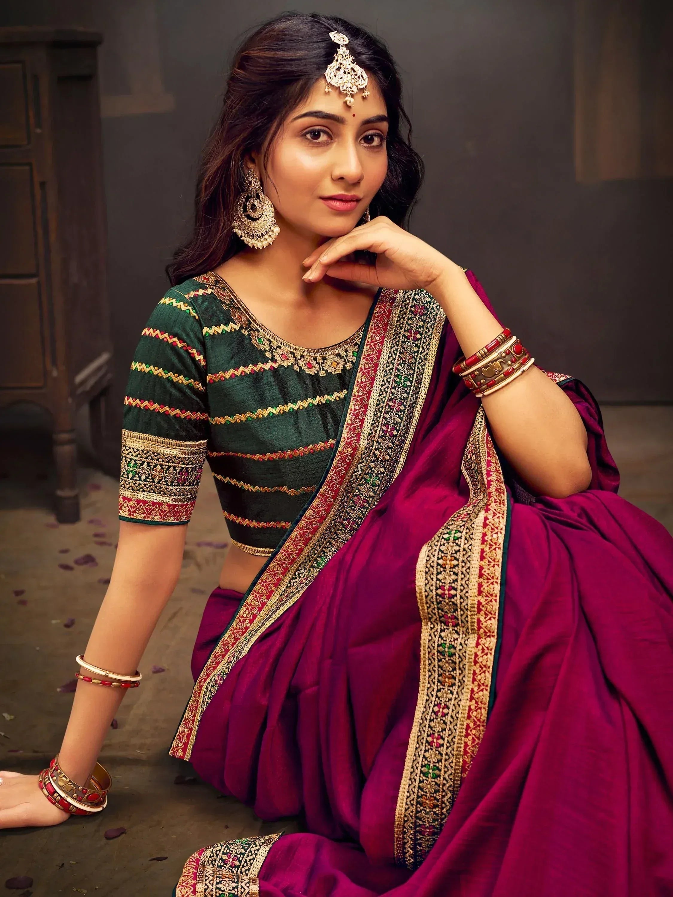 Woman in maroon saree with green embroidered blouse, traditional Indian ethnic wear, gold jewelry