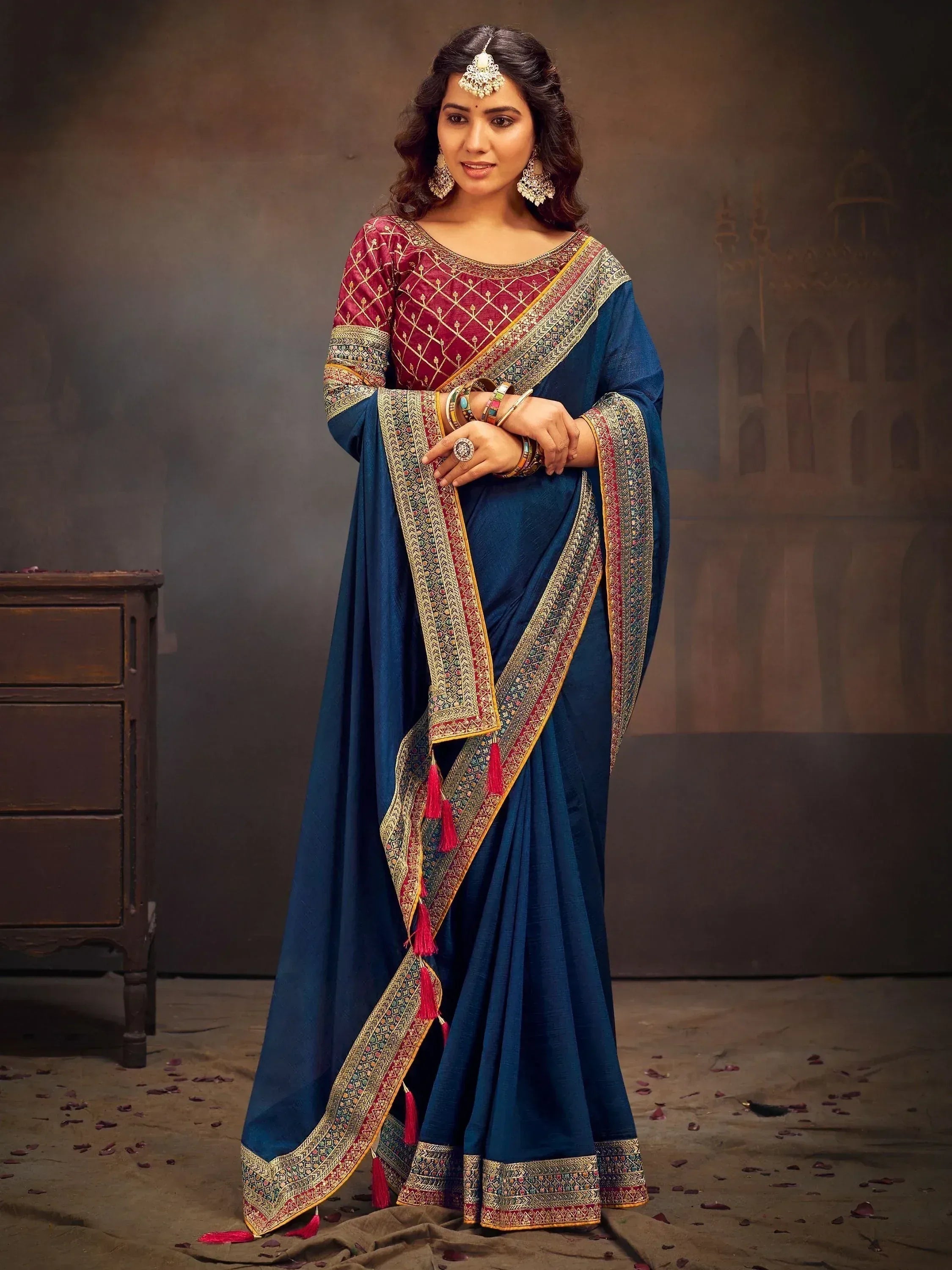 Blue and maroon designer saree with gold embroidery and tassels, paired with matching blouse for ethnic wear