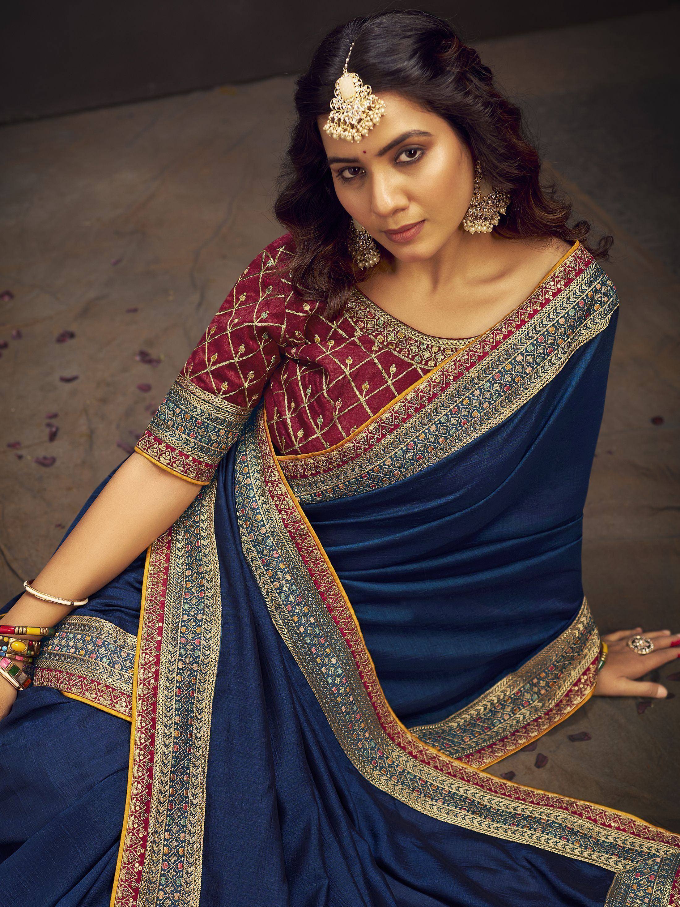 Woman in navy blue saree with gold border and maroon embroidered blouse, traditional Indian ethnic wear