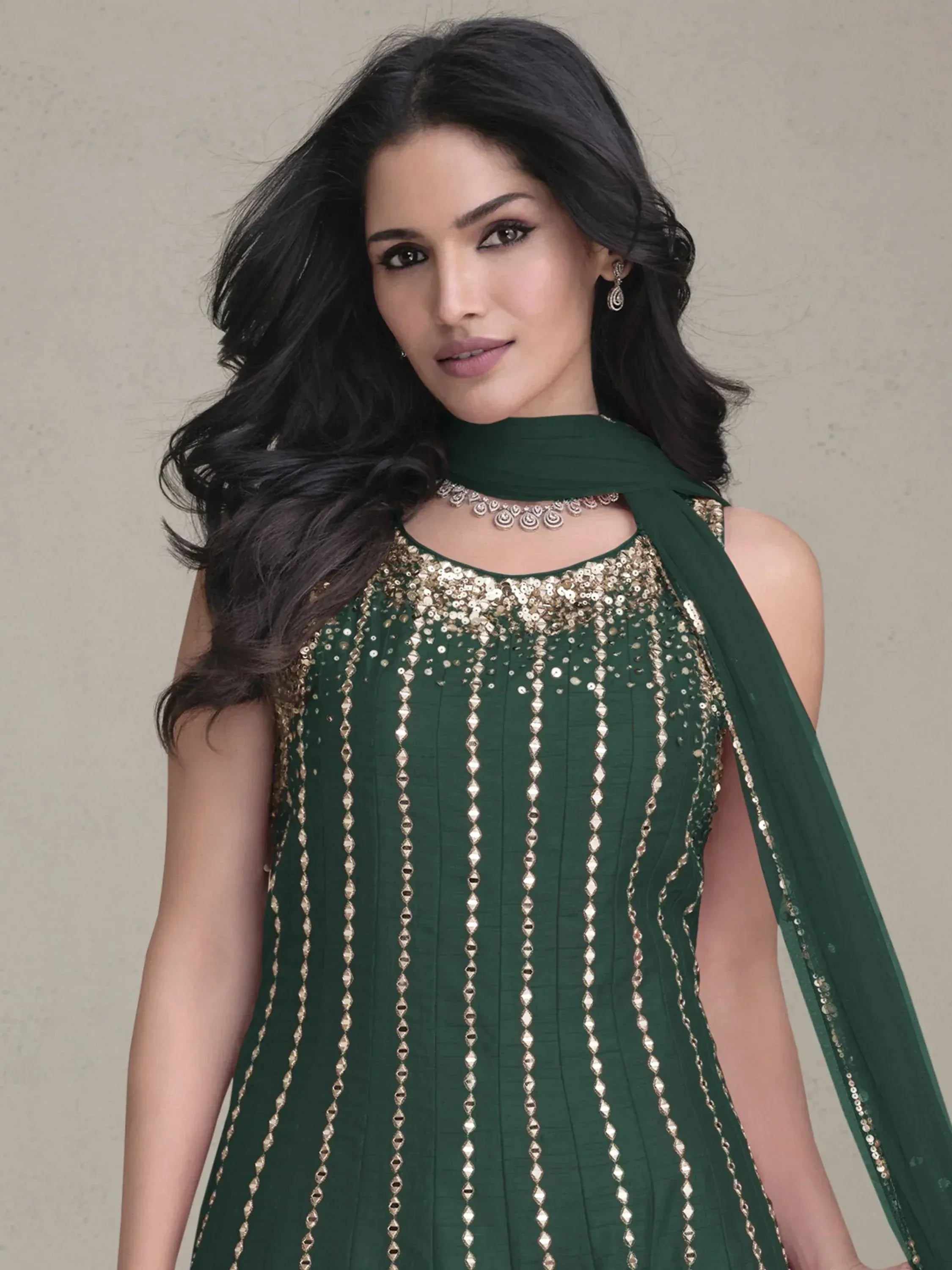 Emerald green ethnic gown with gold sequin embroidery and matching dupatta, perfect for Indian festive occasions.