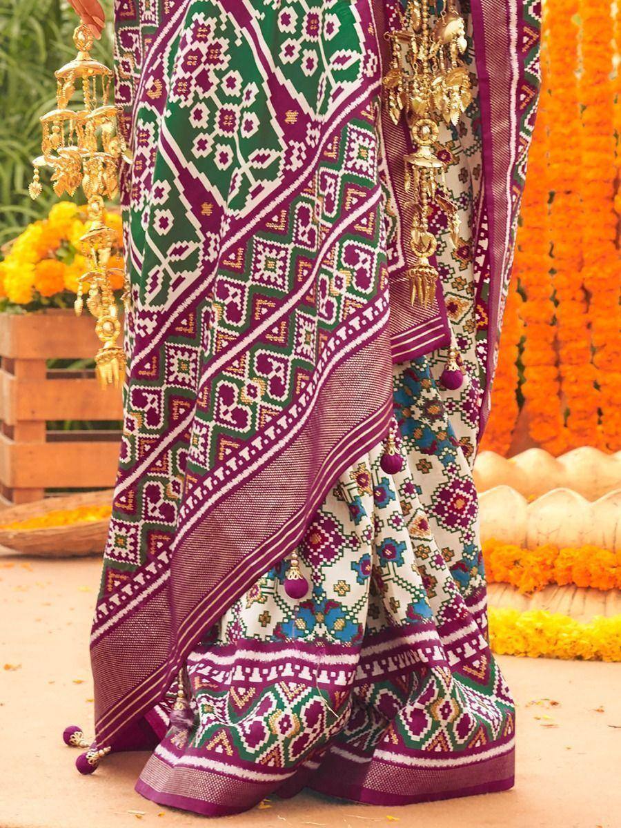 Vibrant purple and green ethnic saree with geometric patterns, perfect for festive occasions