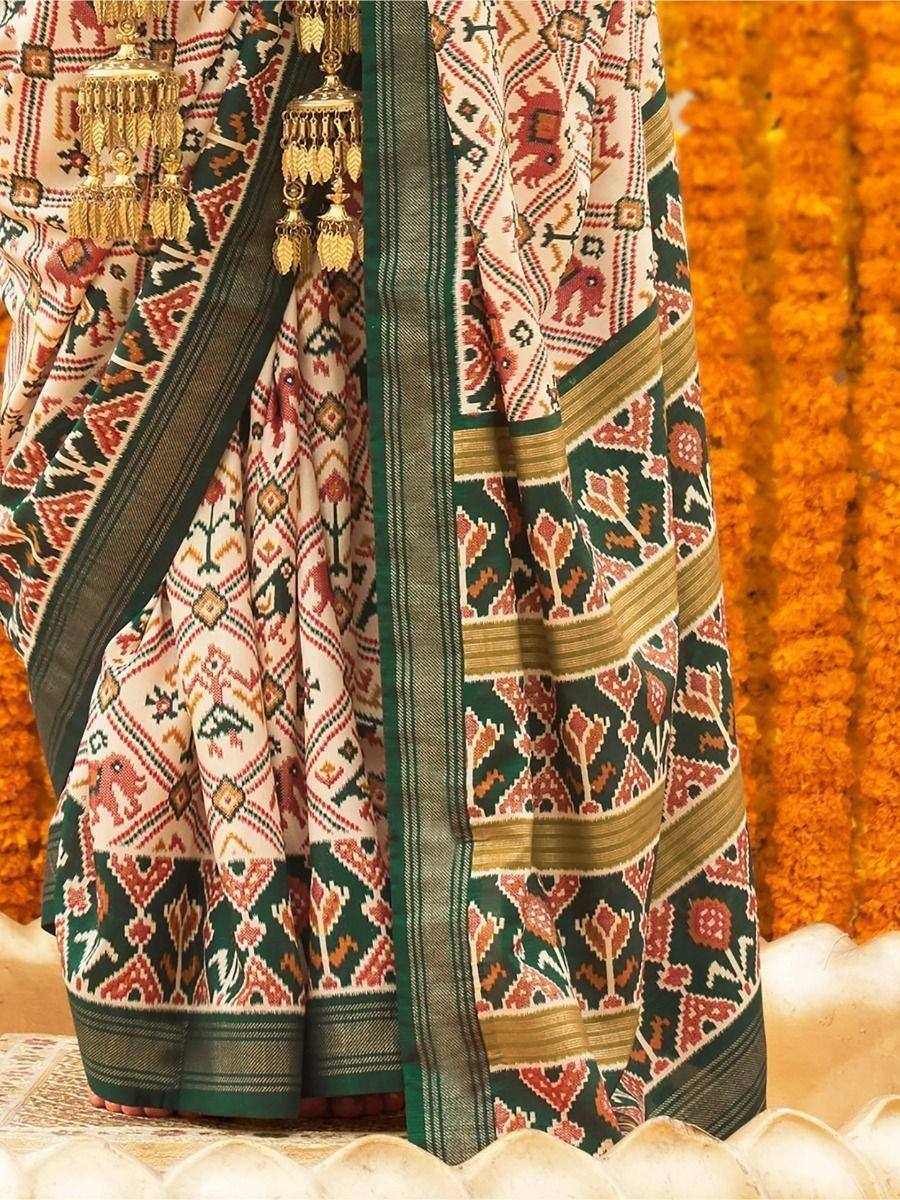 Traditional Indian saree with elephant print, green border, and gold tassels, perfect for ethnic wear occasions.