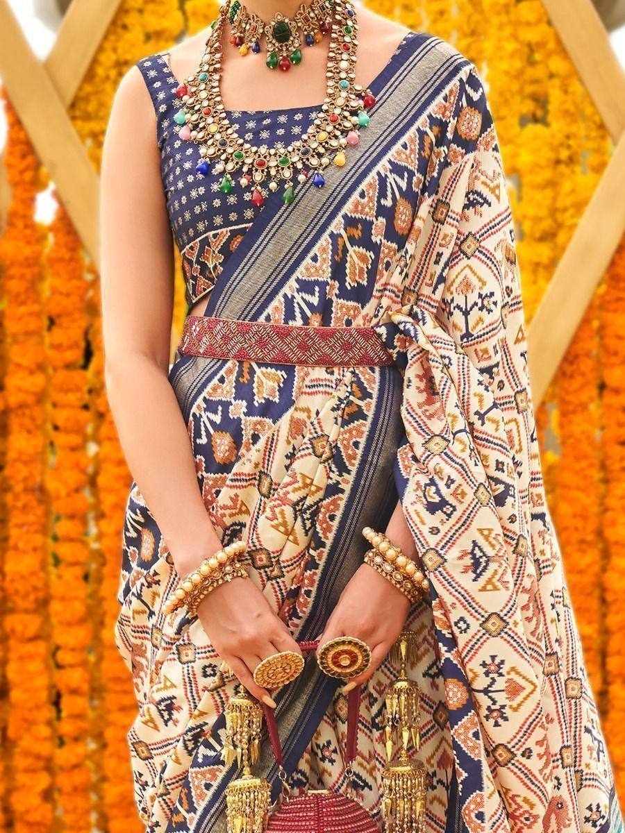 Indian ethnic saree with geometric print, paired with statement jewelry and gold bangles, perfect for festive occasions.