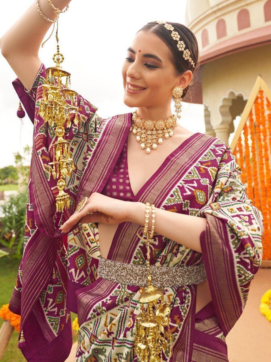 Woman in purple ethnic saree with gold jewelry, holding decorative lantern, traditional Indian attire