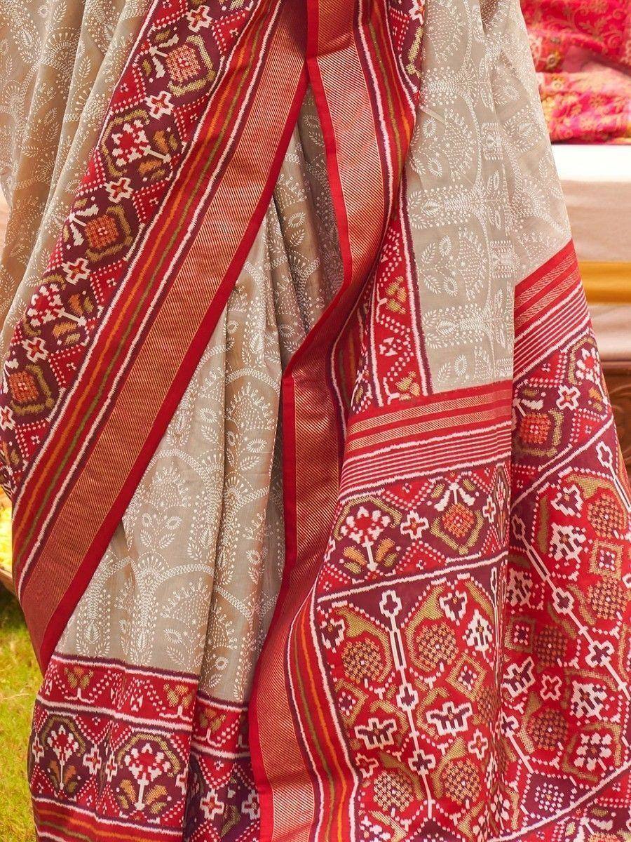 Red and beige ethnic saree with intricate geometric and floral patterns, perfect for Indian traditional wear.