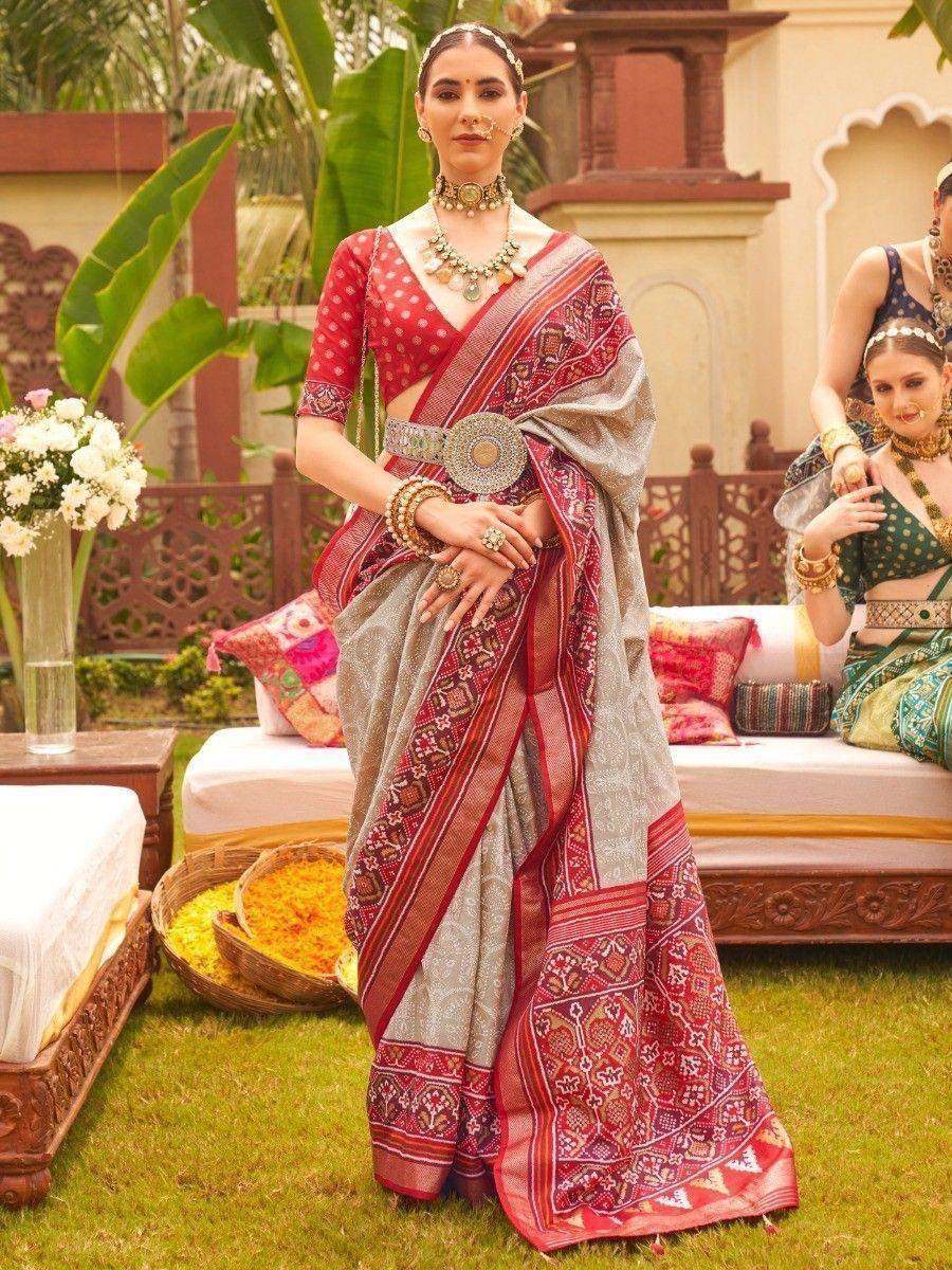 Woman in red and grey printed saree with gold jewelry, traditional Indian ethnic wear