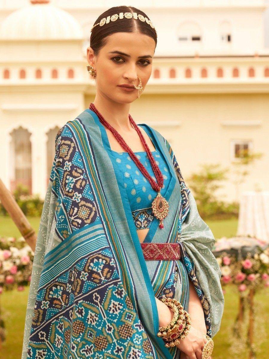 Blue printed saree with ethnic jewelry, perfect for Indian weddings or festive occasions