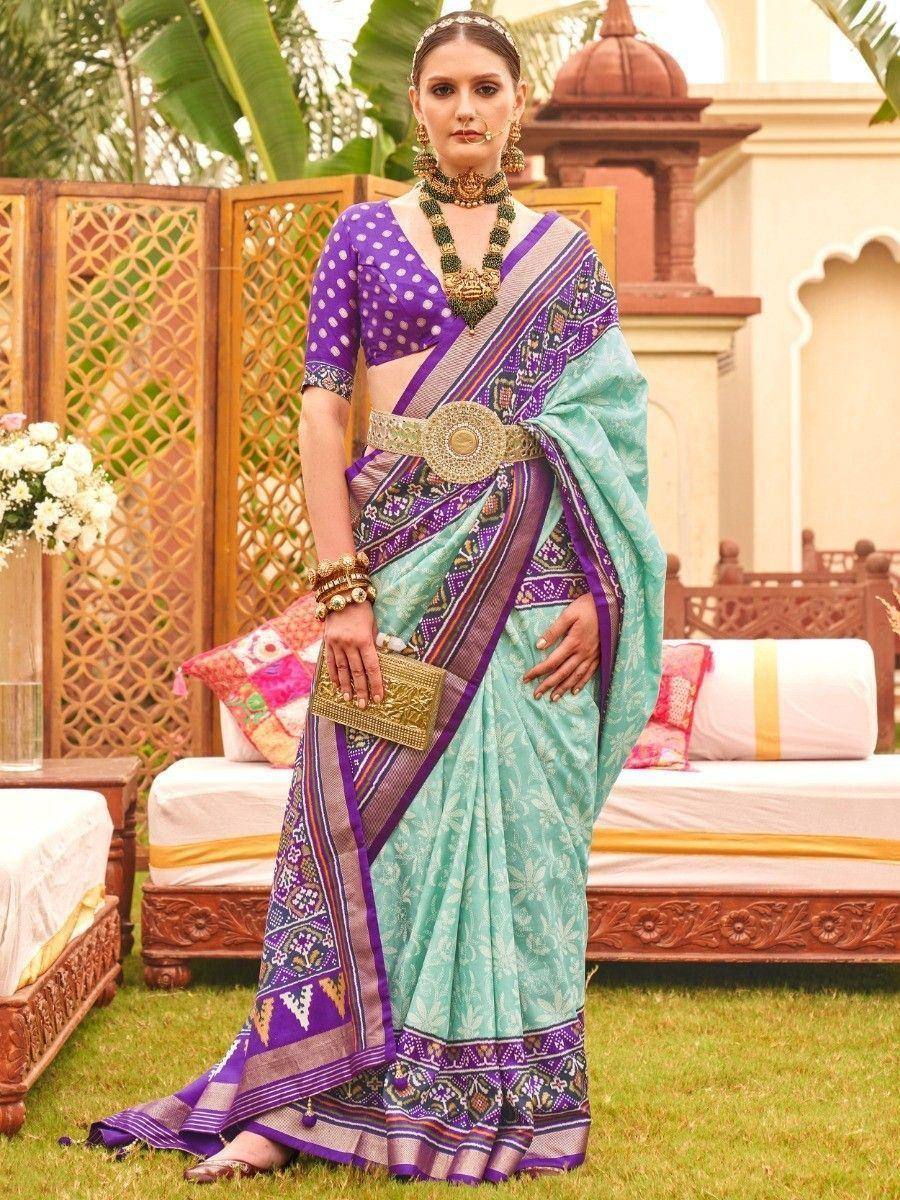 Woman in purple and mint green designer saree with gold belt, perfect for Indian ethnic occasions