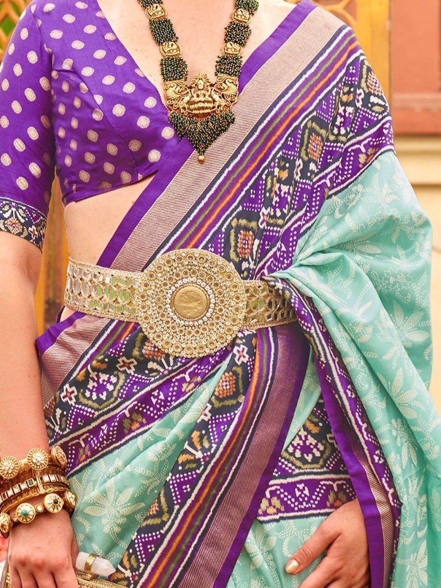 Purple polka dot blouse with patterned saree, gold belt & traditional jewelry for Indian ethnic wear