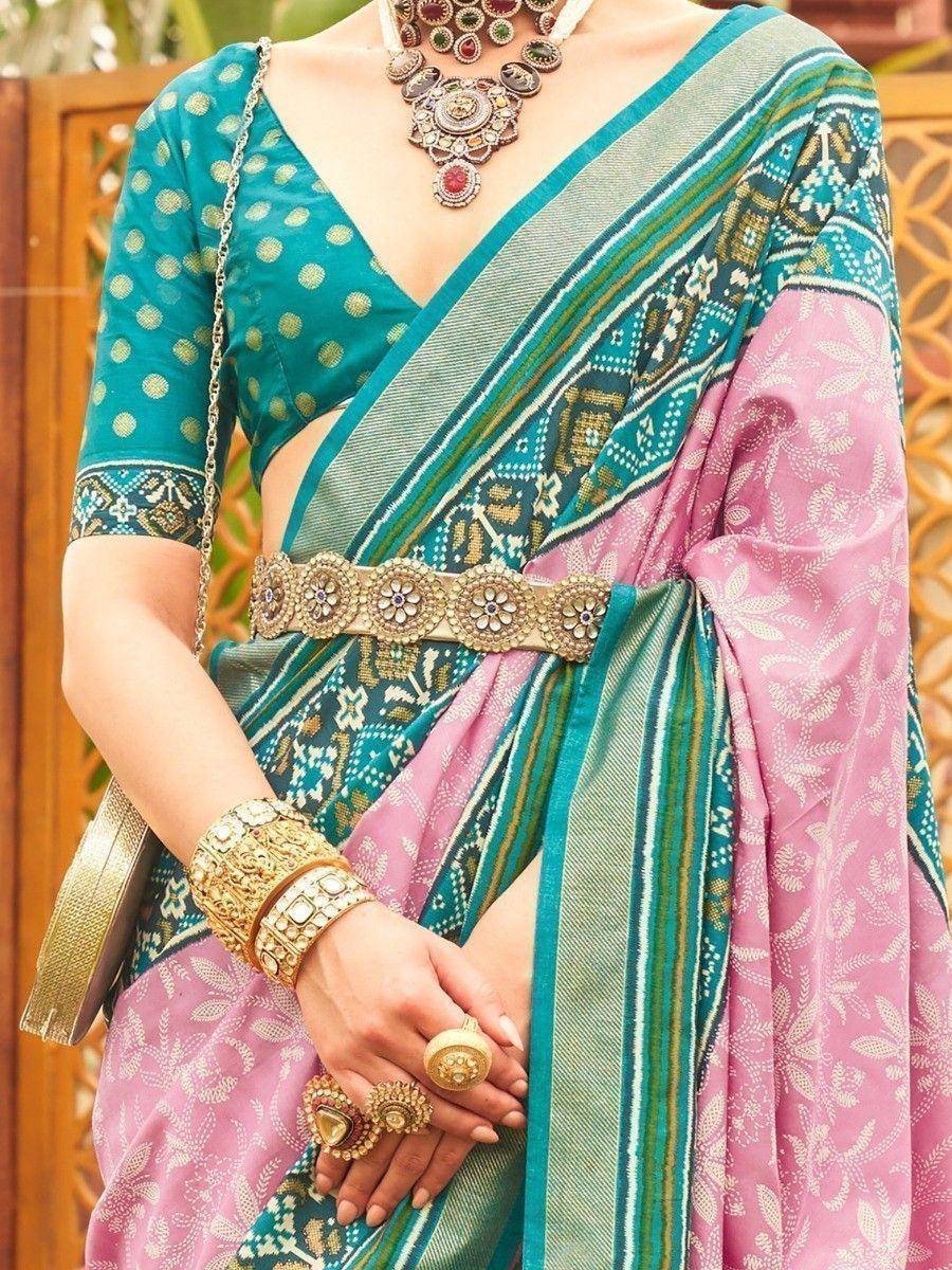 Teal and pink printed saree with gold polka blouse, ethnic jewelry, and embellished belt for Indian occasions