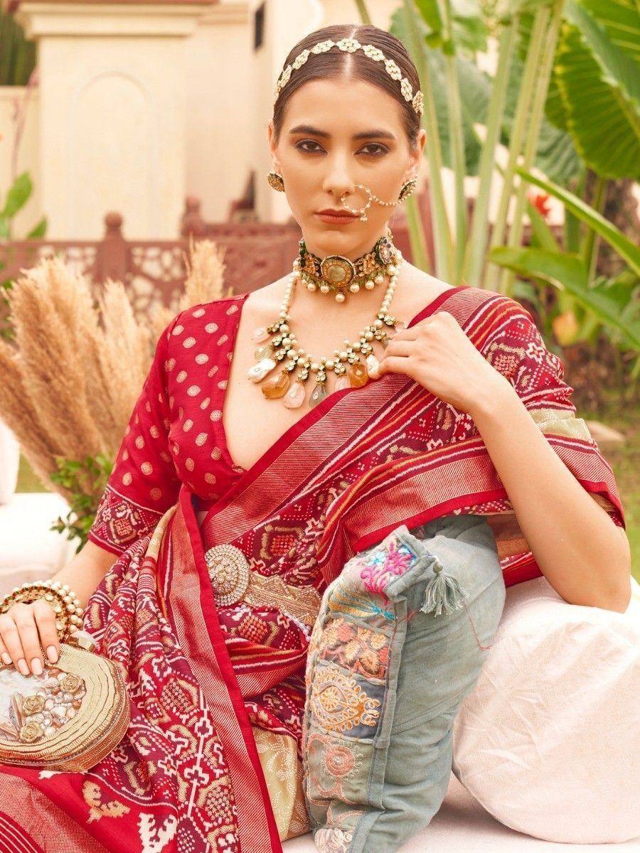 Woman in red printed saree with gold jewelry, ethnic Indian wear, designer lehenga choli style