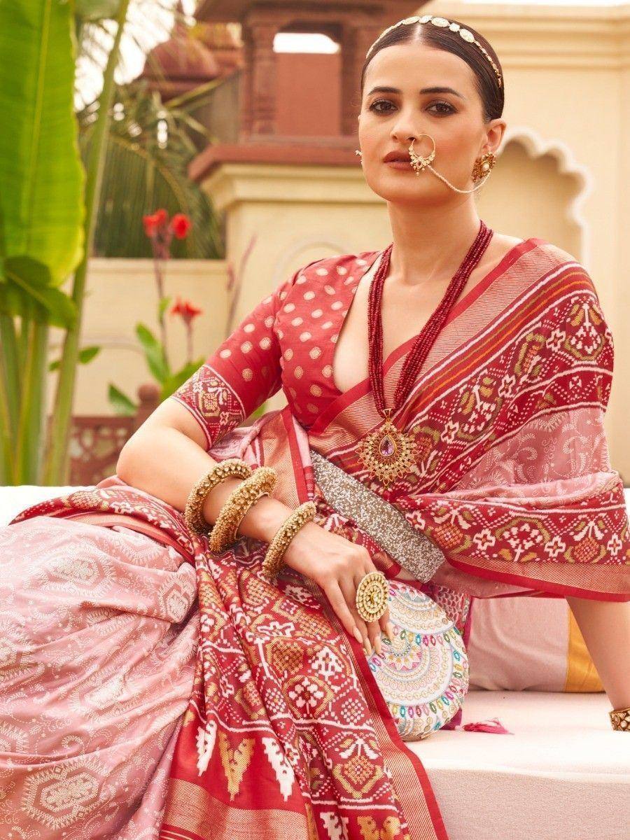 Elegant red and pink ethnic saree with intricate patterns and traditional jewelry