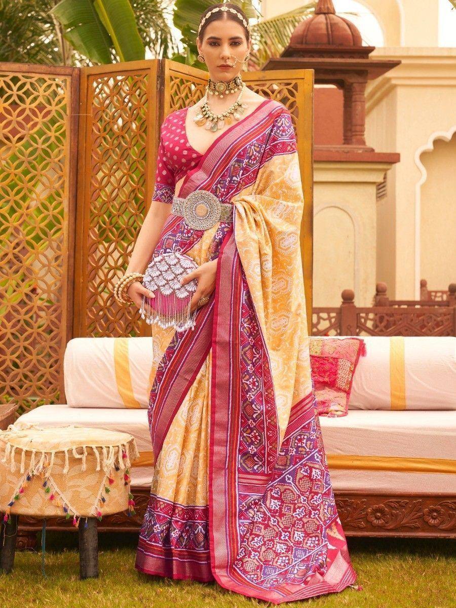 Woman in vibrant pink and gold printed saree with ethnic jewelry, perfect for Indian weddings or festivals