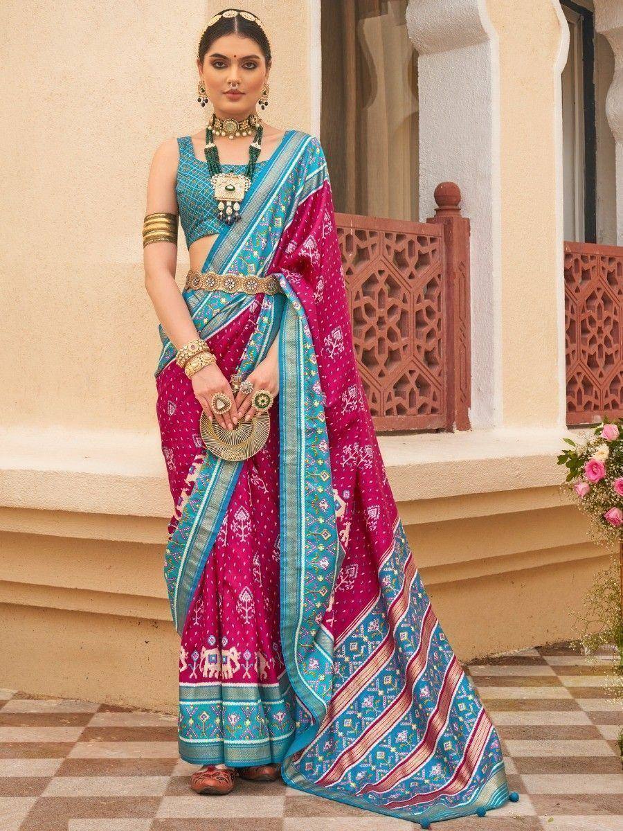 Vibrant pink and blue printed saree with ethnic jewelry, perfect for Indian festive occasions
