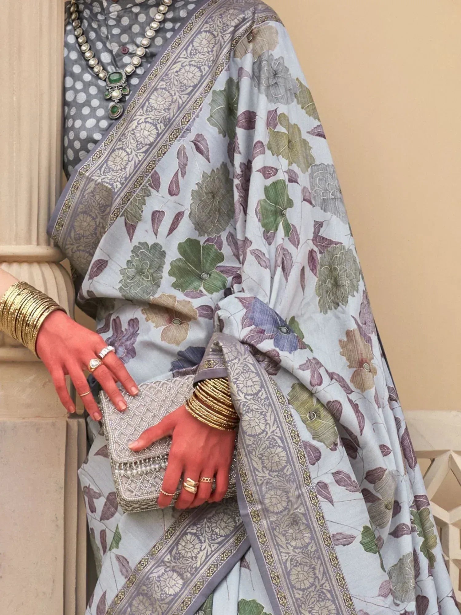 Elegant floral print saree with grey polka dot blouse, traditional jewelry, and gold bangles for ethnic wear