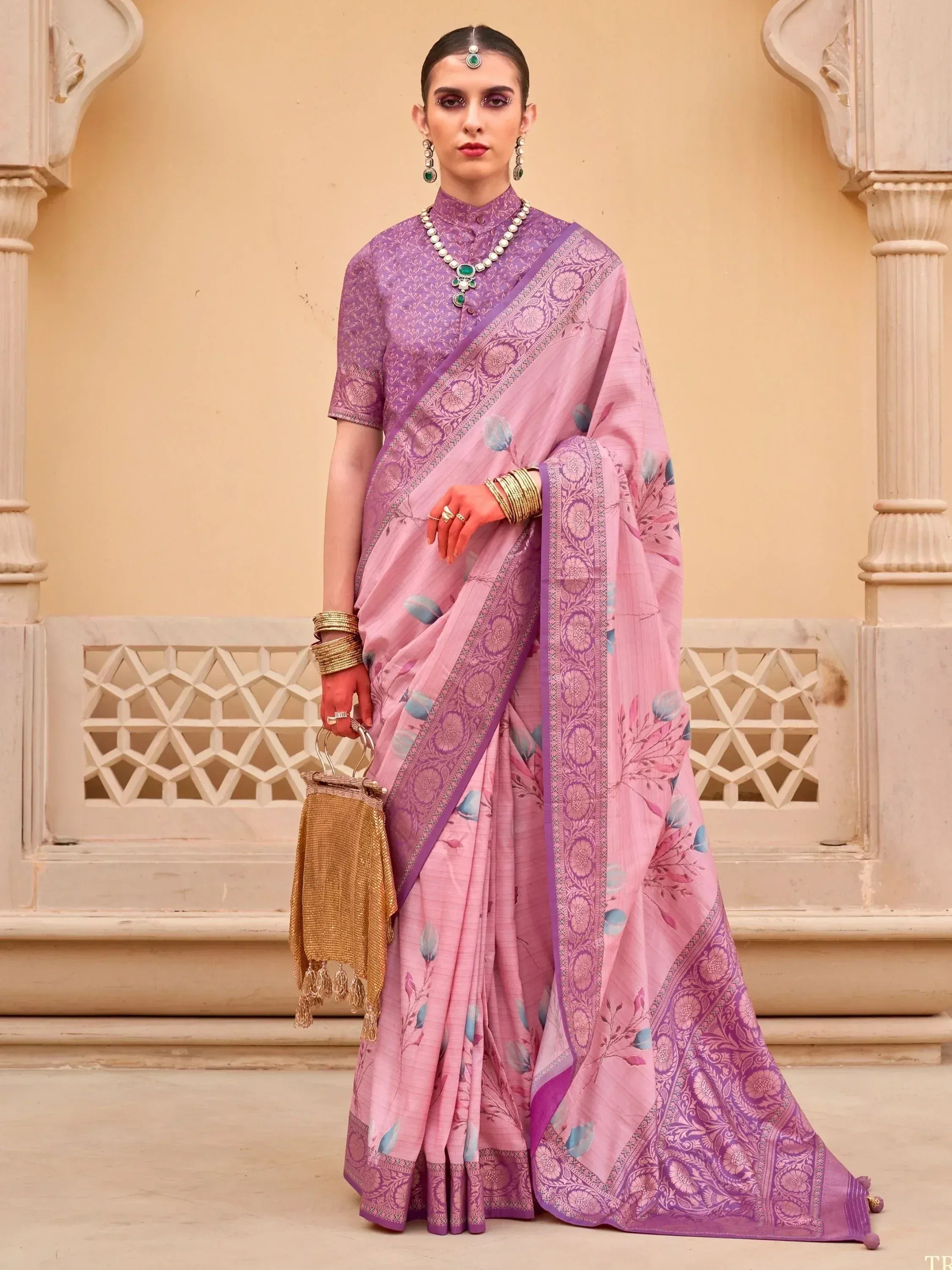 Pink and purple floral saree with intricate border, paired with matching blouse and traditional jewelry