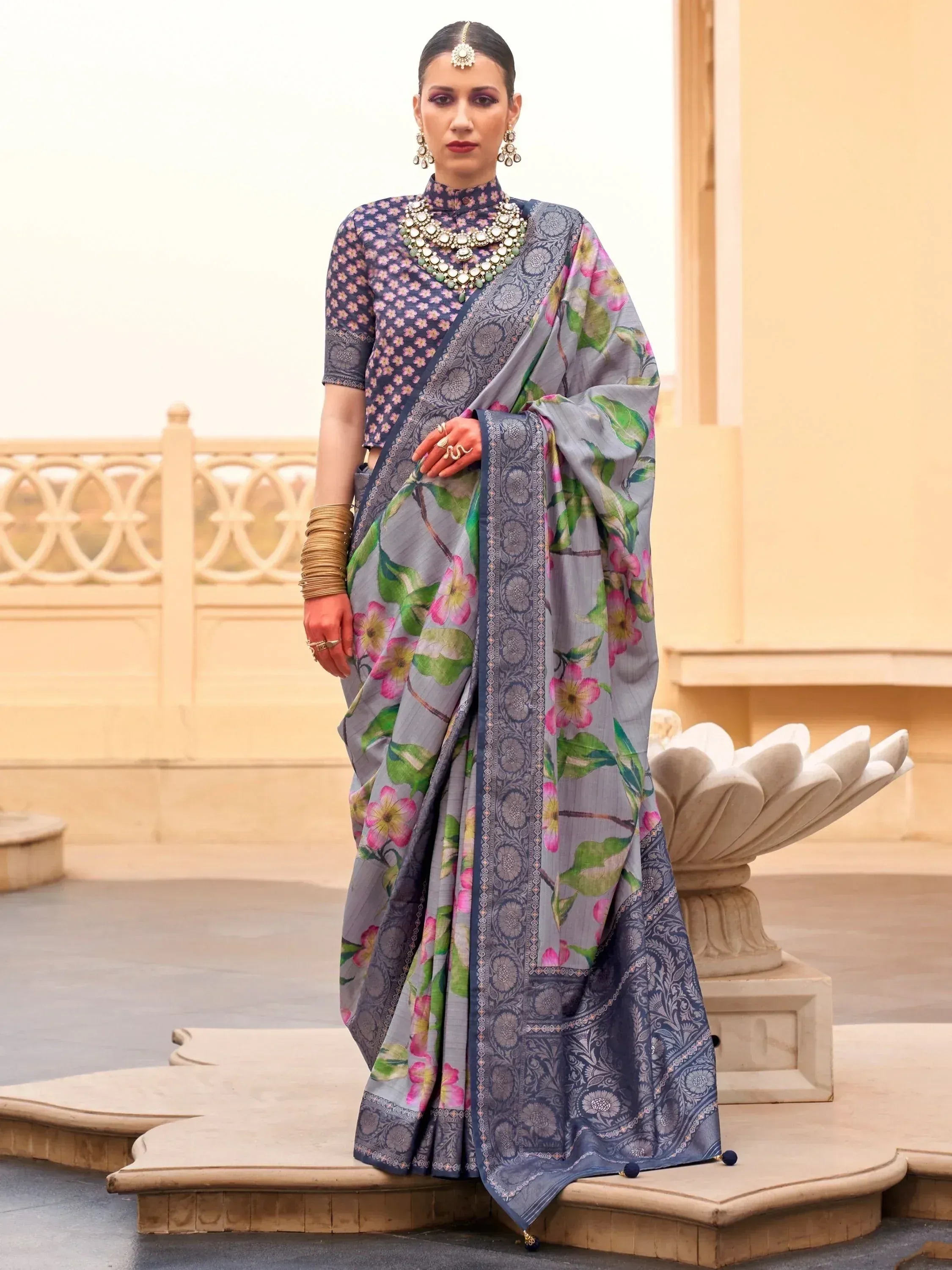 Grey floral print saree with navy blue border, paired with matching blouse, perfect for Indian ethnic occasions.