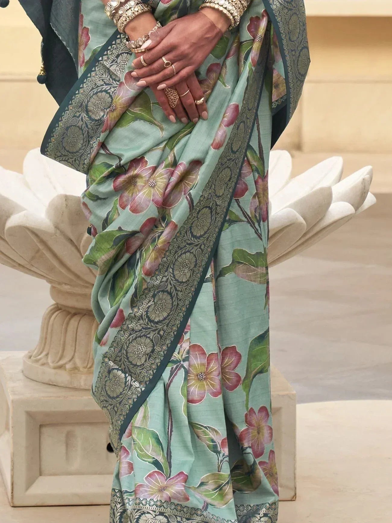 Mint green floral saree with intricate border, styled with traditional jewelry for ethnic wear