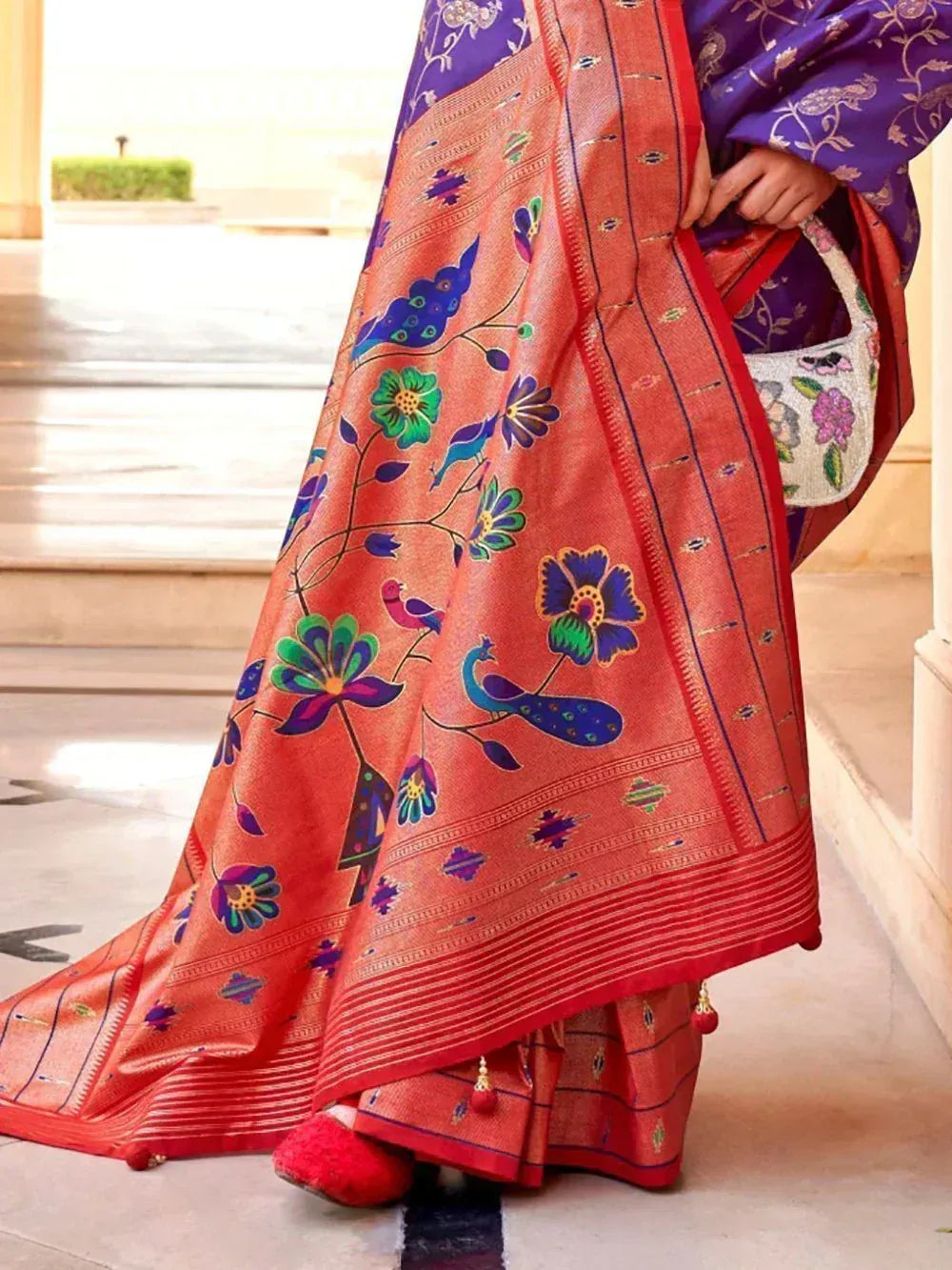 Vibrant orange saree with peacock and floral prints, paired with purple blouse, perfect for ethnic occasions