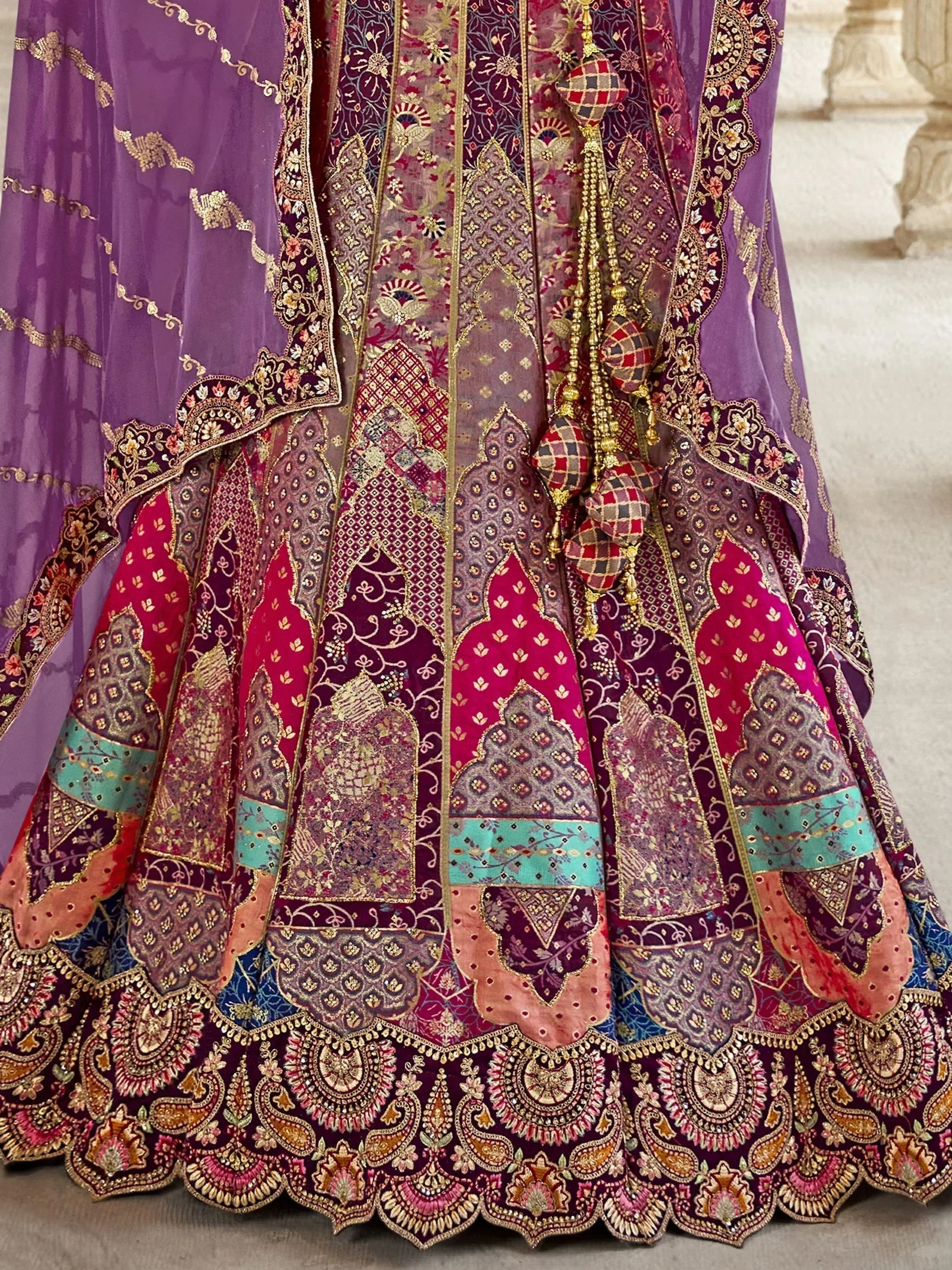 Purple and pink designer lehenga choli with intricate gold embroidery and patchwork detailing