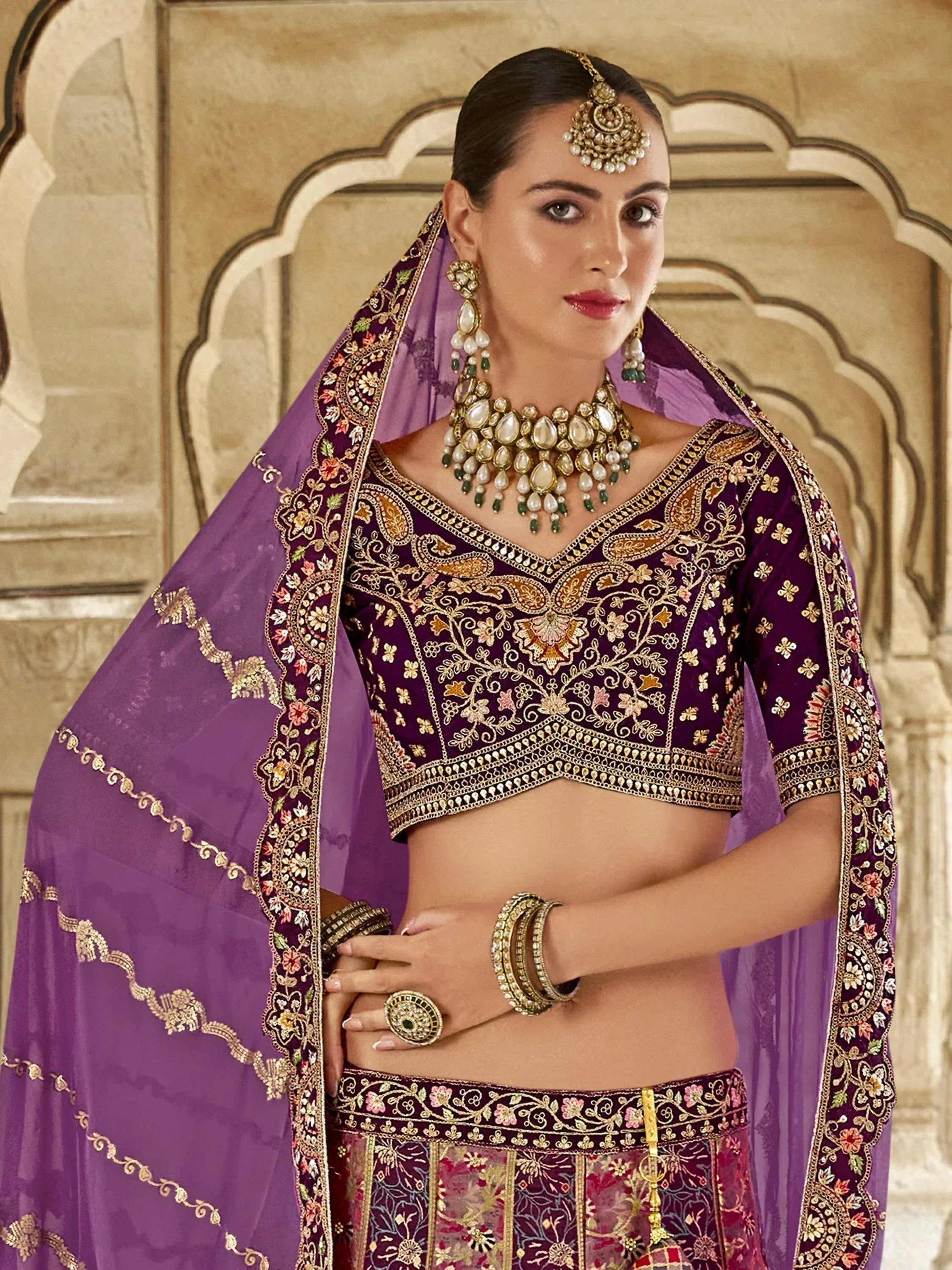 Purple embroidered lehenga choli with gold detailing, traditional Indian ethnic wear for weddings