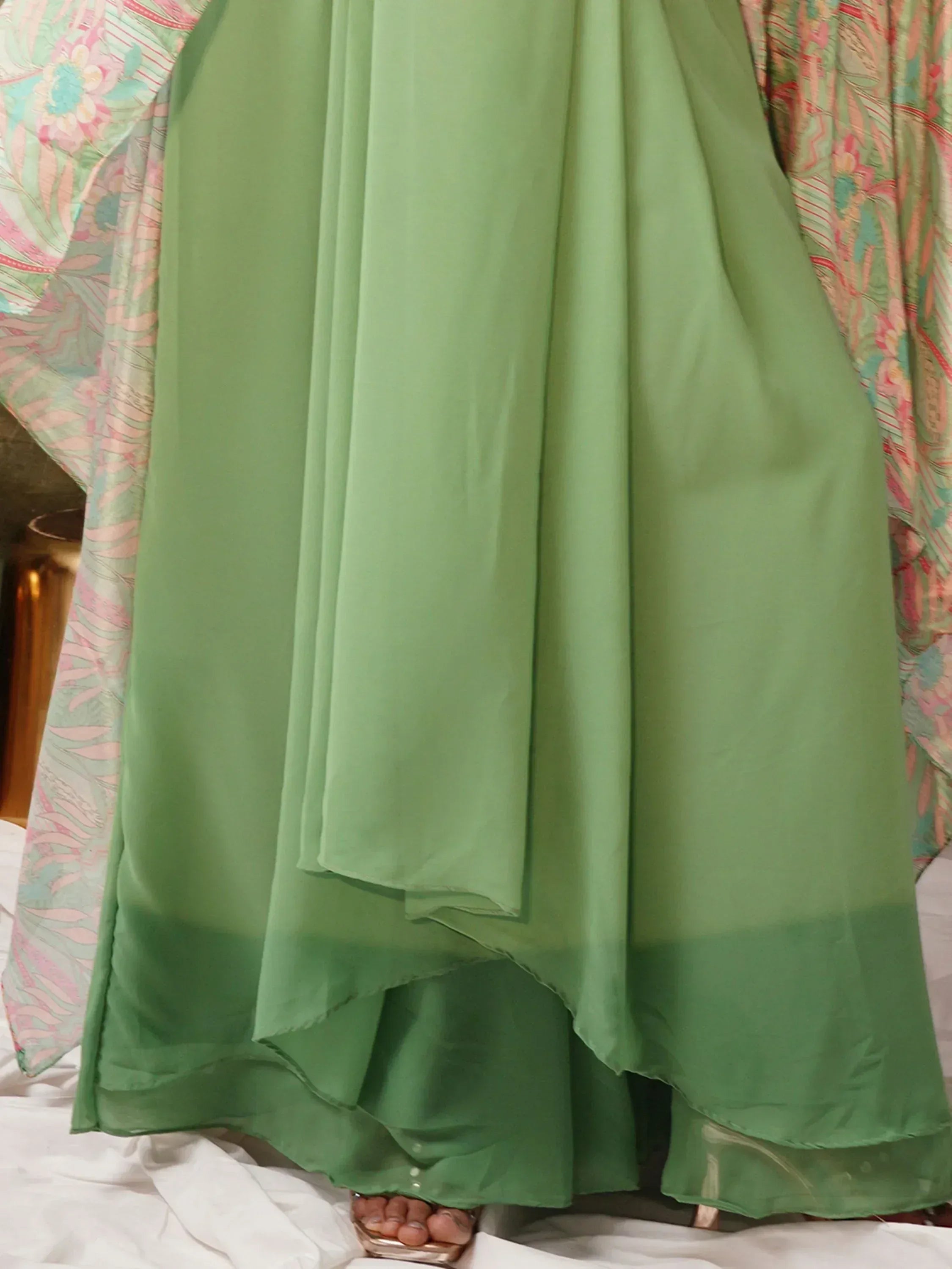 Mint green ethnic gown with layered hem, paired with floral dupatta, perfect for Indian occasions.