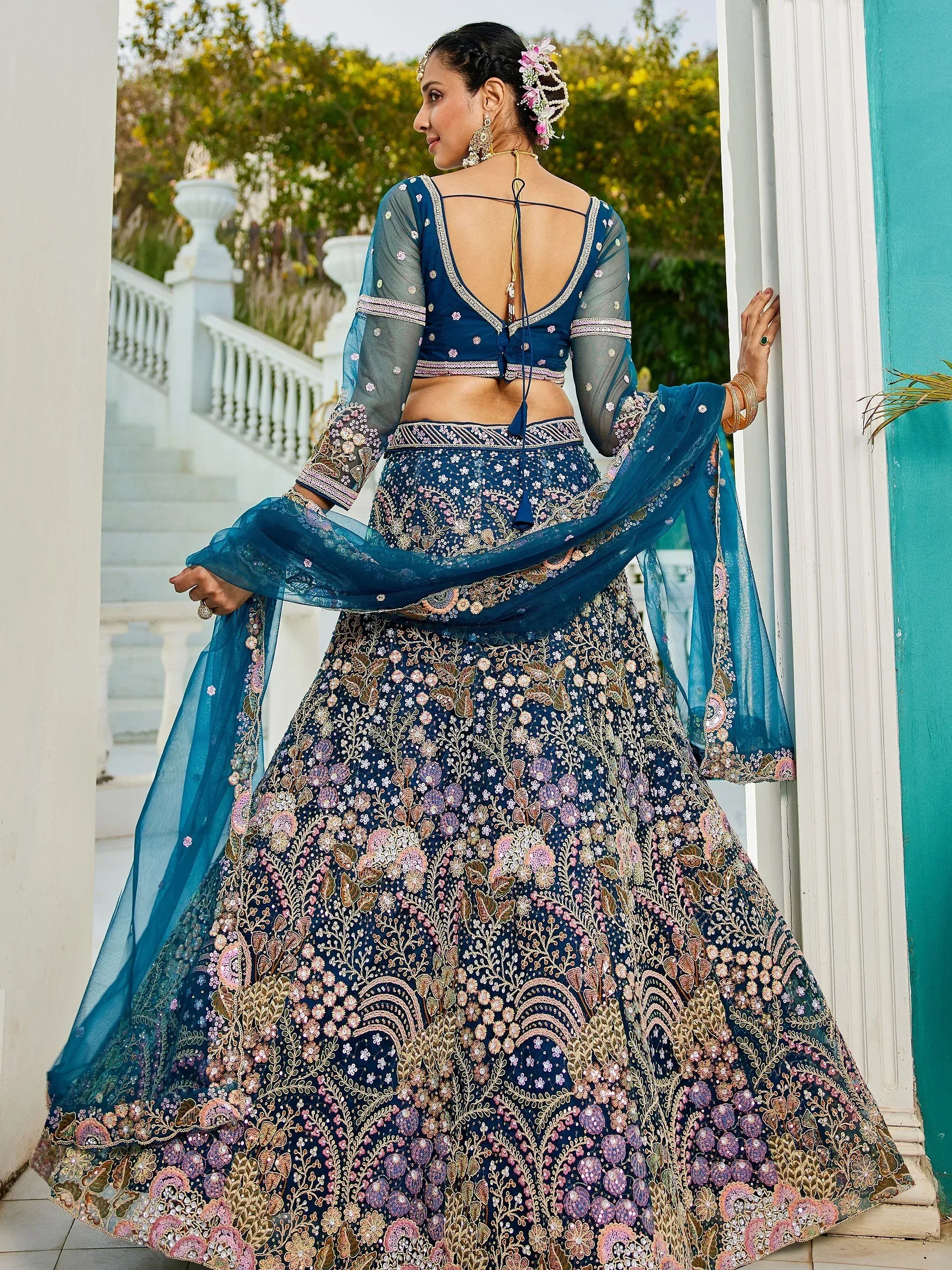 Blue embroidered lehenga choli with floral motifs, sheer sleeves, and dupatta, perfect for Indian ethnic occasions.
