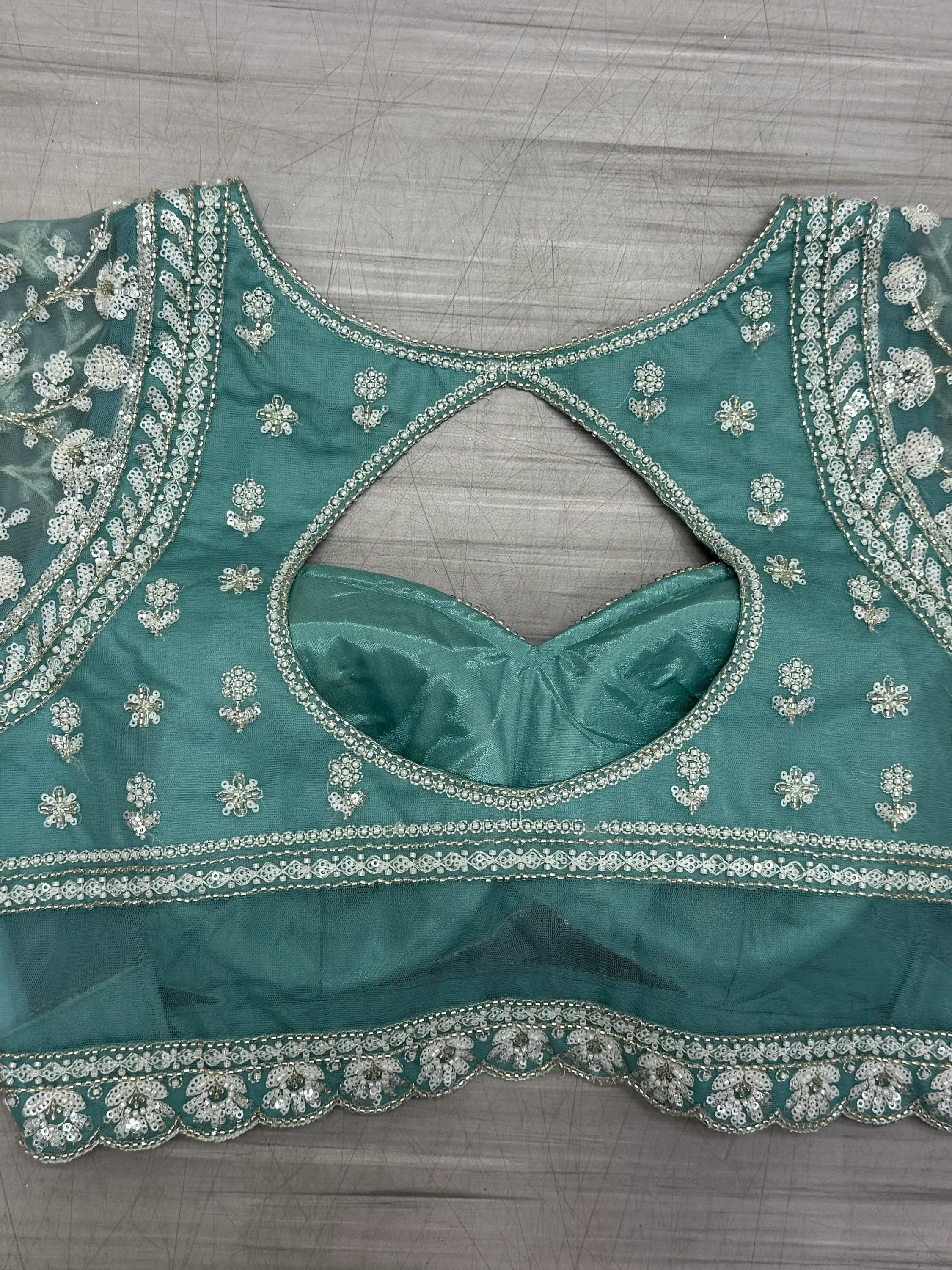 Teal green embroidered blouse with silver floral sequin work and keyhole back, ideal for lehenga choli
