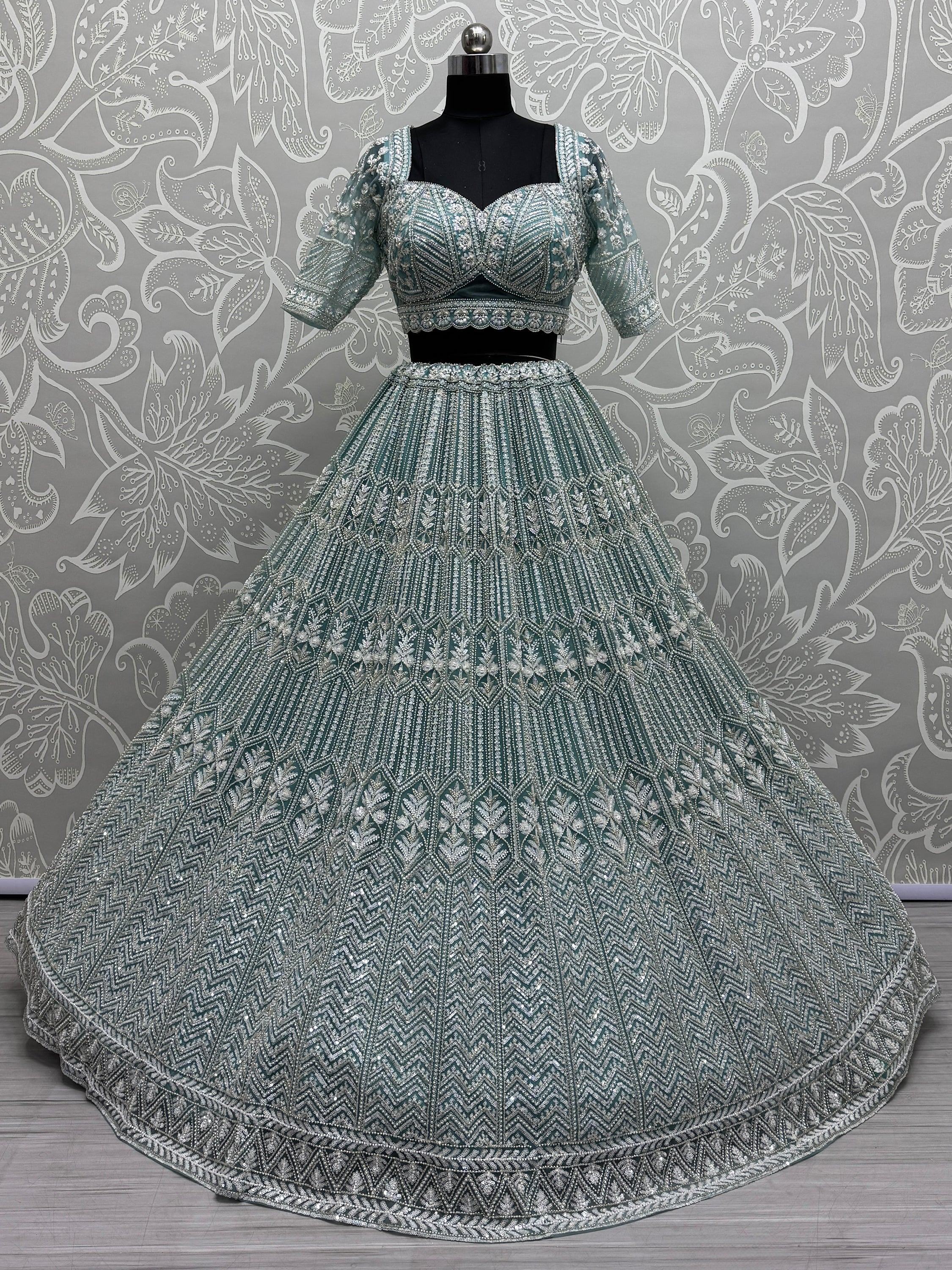 Teal designer lehenga choli with heavy silver embroidery, perfect for Indian weddings and festive occasions.