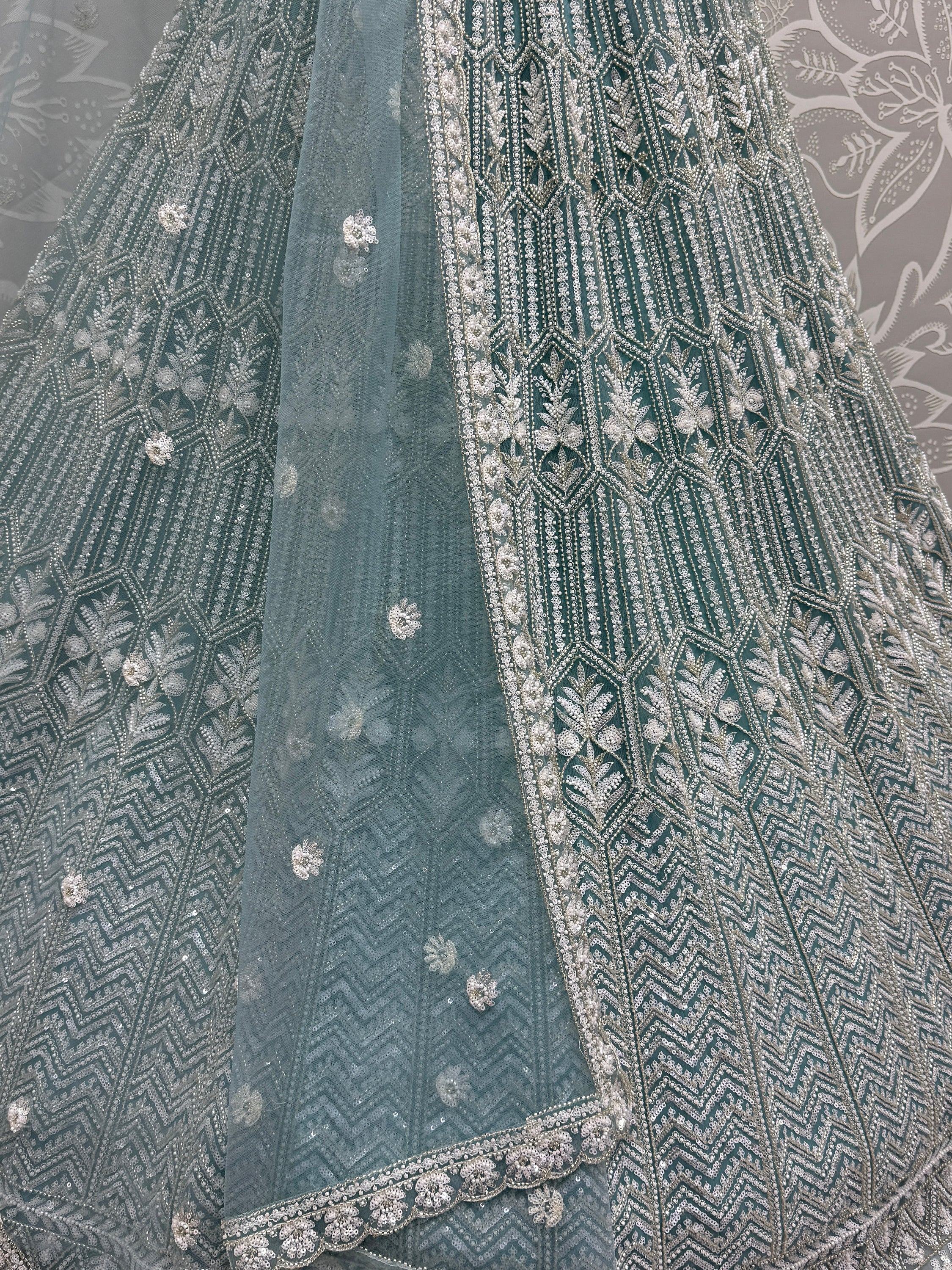 Teal designer lehenga with intricate silver embroidery and sequin work, perfect for Indian ethnic wear.