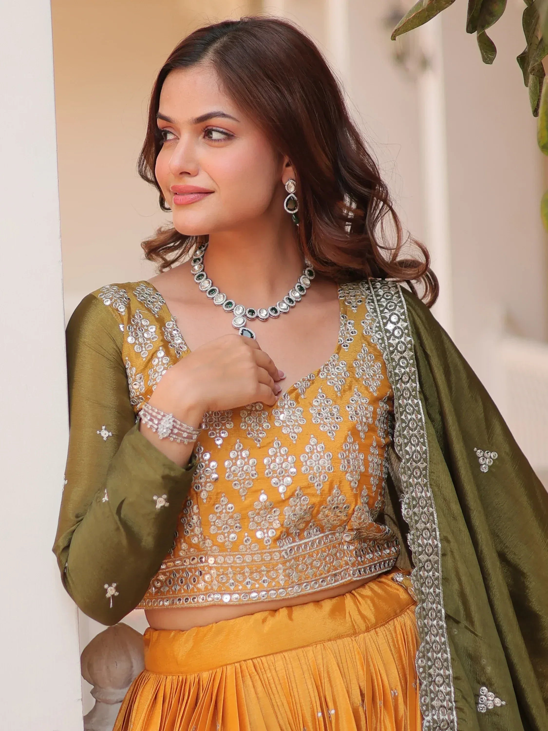 Elegant mustard yellow lehenga choli with silver mirror work and olive dupatta, perfect for Indian ethnic occasions.