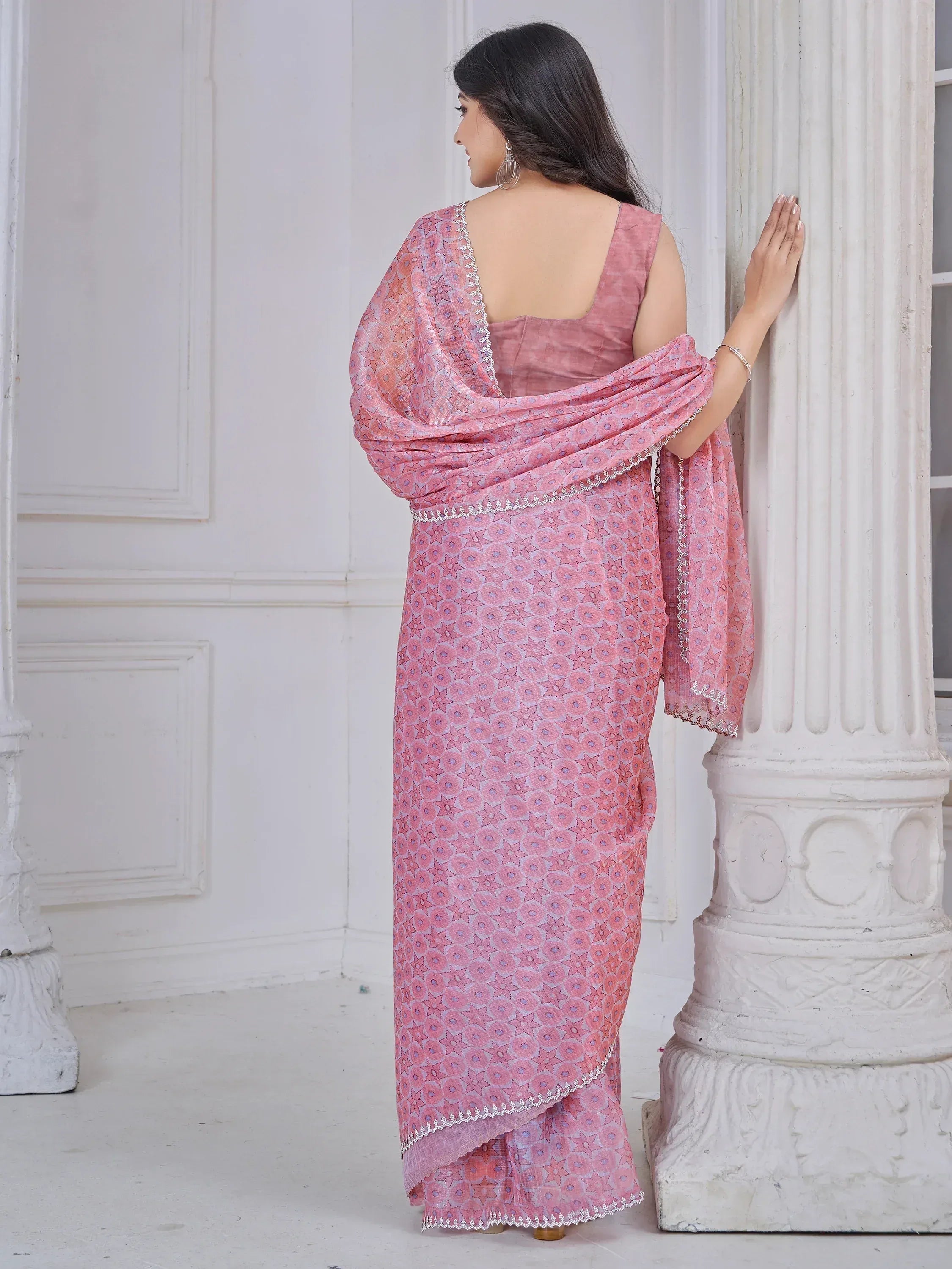 Pink printed saree with lace trim, styled with sleeveless blouse, perfect for ethnic occasions