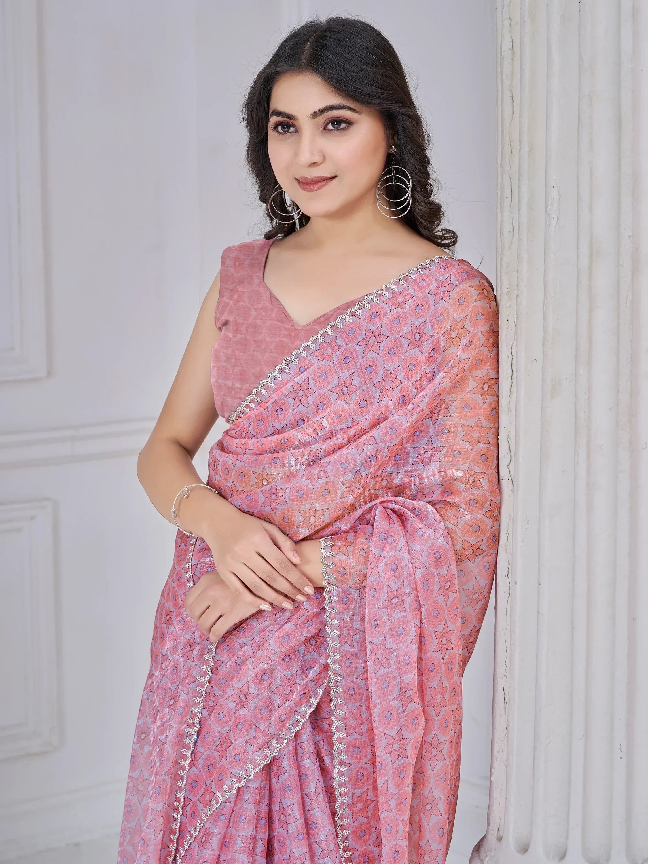 Woman in pink floral saree with silver border, ethnic Indian wear for festive occasions